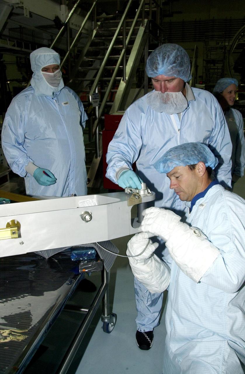 KENNEDY SPACE CENTER, FLA. -- Under the watchful eyes of Boeing workers, STS-113 Mission Specialist John Herrington practices working on equipment involved in his mission during Crew Equipment Interface Test activities in the Space Station Processing Facility. Part of the payload on mission STS-113 is the first port truss segment, P1 Truss, to be attached to the central truss segment, S0, on the International Space Station. Once delivered, the P1 truss will remain stowed until flight 12A.1. Launch date for STS-113 is under review.