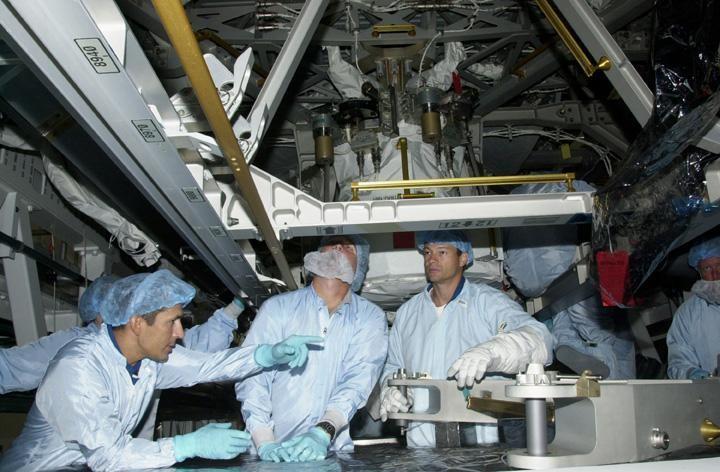 KENNEDY SPACE CENTER, FLA. - Under the eyes of a Boeing worker (center), STS-113 Mission Specialist John Herrington (left) and Mission Specialist Michael Lopez-Alegria (right) learn more about the payload for their mission. Part of the payload on mission STS-113 is the first port truss segment, P1 Truss, to be attached to the central truss segment, S0, on the International Space Station.  Once delivered, the P1 truss will remain stowed until flight 12A.1.  Launch date for STS-113 is under review.