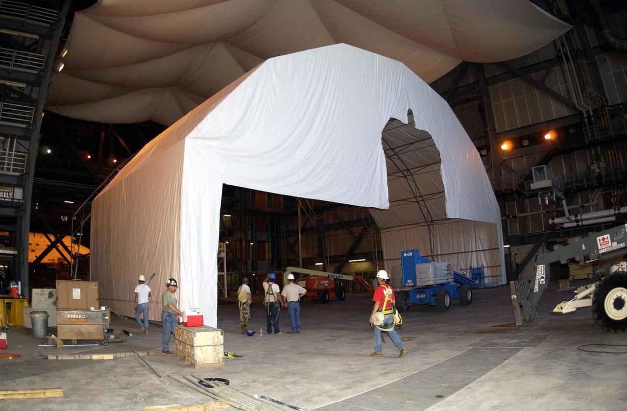 KENNEDY SPACE CENTER, FLA. -- In Vehicle Assembly Building (VAB) high bay 4, installation of a Payload Bay Door Drying Enclosure is in progress.  The enclosure will keep moisture from being absorbed into the graphite epoxy used on the payload bay doors of the Shuttle orbiters with the assistance of mini-Portable Purge Units (PPUs).  Once in operation, the enclosure will allow NASA the option to store an orbiter in the VAB bay up to 180 days in a "standby-to-stack" mode.
