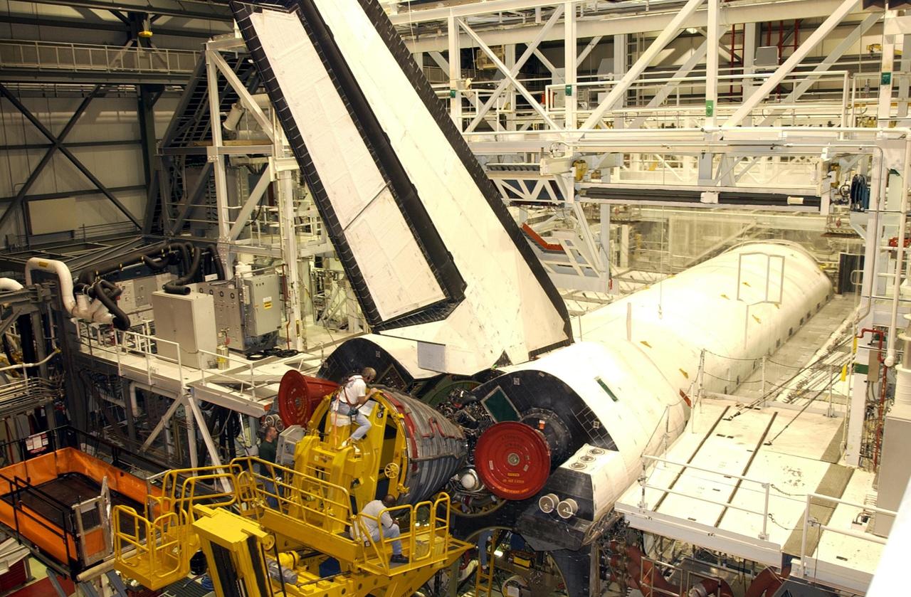 KENNEDY SPACE CENTER, FLA. -- The first Space Shuttle Main Engine (SSME) is installed on Space Shuttle Atlantis following the welding repair of the propulsion system flow liners as preparations to launch mission STS-112 continue. Angela DiMattia is the move director for Rocketdyne. Rocketdyne employee Gerald Braham is seen here behind the engine offering additional guidance. Below him are Mark Starr (left) and Teryon Jones (right), both employees of Rocketdyne. Mission STS-112 is an assembly flight to the International Space Station and is targeted for launch no earlier than Sept. 28, 2002. Members of the STS-112 crew are Commander Jeffrey Ashby; Pilot Pamela Melroy; and Mission Specialists David Wolf, Piers Sellers, Sandra Magnus, and Fyodor Yurchikhin of the Russian Space Agency.