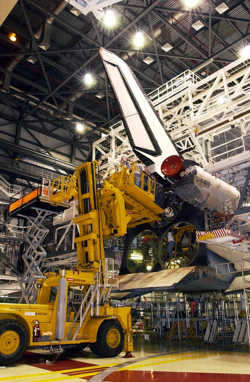 KENNEDY SPACE CENTER, FLA. -- The first Space Shuttle Main Engine (SSME) is installed on Space Shuttle Atlantis following the welding repair of the propulsion flow liners as preparations to launch mission STS-112 continue. Angela DiMattia is the move director for Rocketdyne. Rocketdyne employee Gerald Braham is seen here behind the engine offering additional guidance. Below him is Teryon Jones (right), also of Rocketdyne. Mission STS-112 is an assembly flight to the International Space Station and is targeted for launch no earlier than Sept. 28, 2002. Members of the STS-112 crew are Commander Jeffrey Ashby; Pilot Pamela Melroy; and Mission Specialists David Wolf, Piers Sellers, Sandra Magnus, and Fyodor Yurchikhin of the Russian Space Agency.