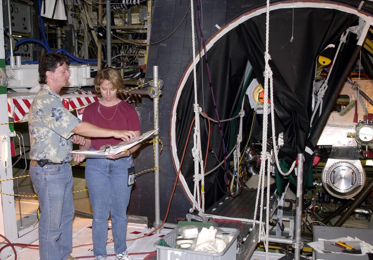 KENNEDY SPACE CENTER, FLA. -- James Stickley and Kristin Rumpf, both with United Space Alliance - Main Propulsion System Engineering, discuss procedures about welding the minute cracks on Endeavour's flow liners. Endeavour is scheduled to fly on mission STS-113 in November. The mission payload is the P1 Integrated Truss Structure, the first portside truss to go to the International Space Station, and will be attached to the central truss segment, S0, on the Station. Also additional cooling radiators will be delivered but will remain stowed until flight 12A.1.