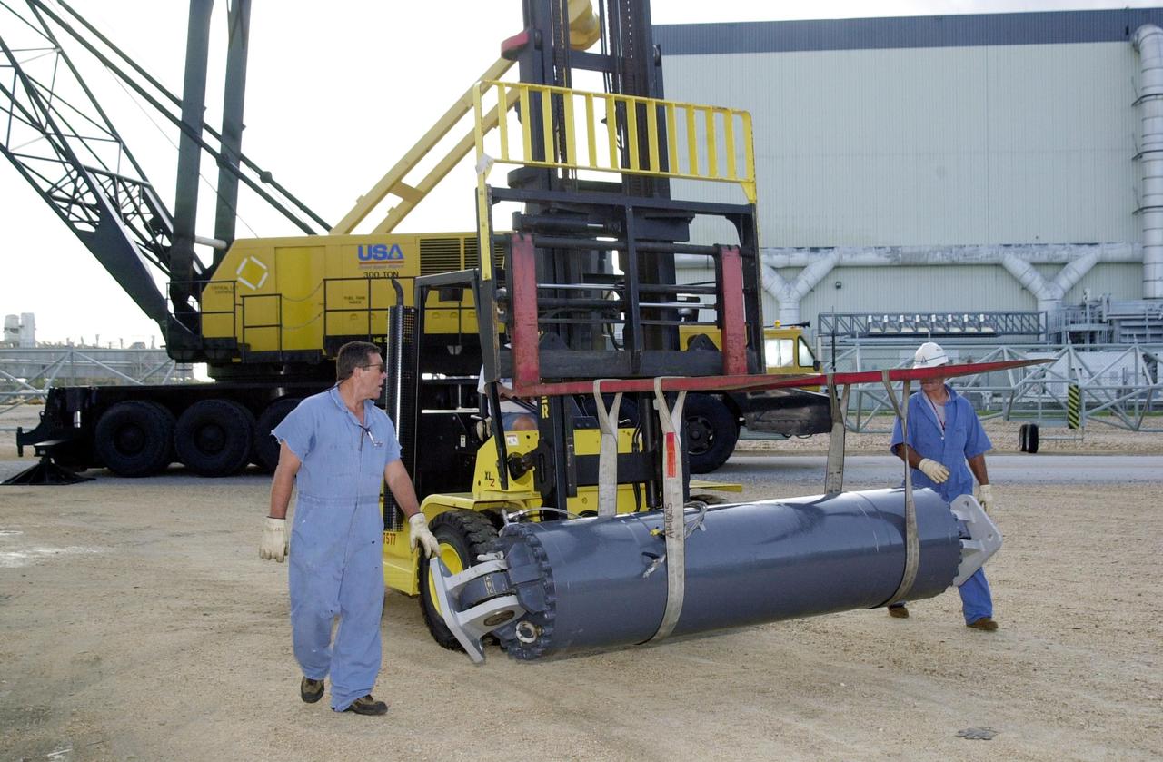 KENNEDY SPACE CENTER, FLA. --  Workers accompany the repaired Jacking, Equalization and Leveling (JEL) cylinder as it is moved from the repair site for installation into Crawler Transporter No. 2.  There are 16 cylinders and 32 bearings per crawler.  During recent routine maintenance inspections, technicians removed two of the 16 JEL cylinders on the crawler to gain access to the bearings and found three of the four bearings cracked.  Further eddy current inspections indicated that cracks were present on 15 of the bearings.. Technicians have removed and replaced 14 of the bearings on  CT-2, which is being repaired in order to enable Atlantis' rollout for mission STS-112, scheduled for launch no earlier than Oct. 2.