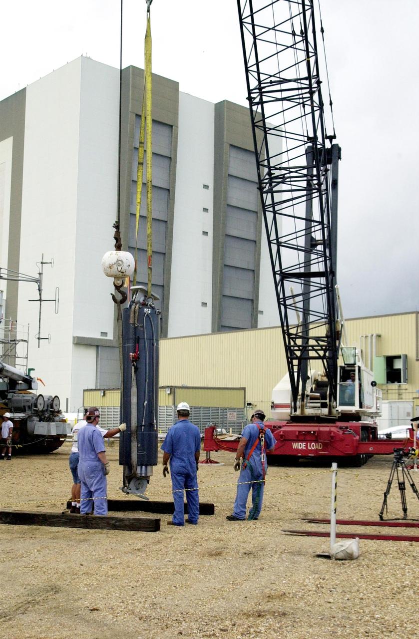 KENNEDY SPACE CENTER, FLA. --  A crane lifts the repaired Jacking, Equalization and Leveling (JEL) cylinder to move into to Crawler Transporter No. 2. There are 16 cylinders and 32 bearings per crawler.  During recent routine maintenance inspections, technicians removed two of the 16 JEL cylinders on the crawler to gain access to the bearings and found three of the four bearings cracked.  Further eddy current inspections indicated that cracks were present on 15 of the bearings.. Technicians have removed and replaced 14 of the bearings on  CT-2, which is being repaired in order to enable Atlantis' rollout for mission STS-112, scheduled for launch no earlier than Oct. 2.