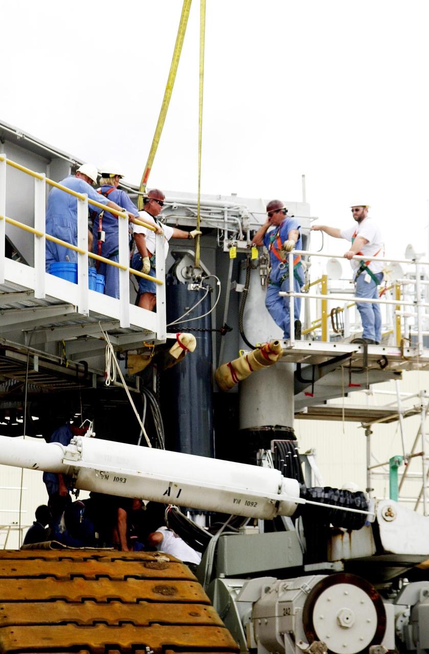 KENNEDY SPACE CENTER, FLA. --  Near the bottom of the repaired Jacking, Equalization and Leveling (JEL) cylinder, workers fasten the JEL to Crawler Transporter No. 2. There are 16 cylinders and 32 bearings per crawler.  During recent routine maintenance inspections, technicians removed two of the 16 JEL cylinders on the crawler to gain access to the bearings and found three of the four bearings cracked.  Further eddy current inspections indicated that cracks were present on 15 of the bearings.. Technicians have removed and replaced 14 of the bearings on  CT-2, which is being repaired in order to enable Atlantis' rollout for mission STS-112, scheduled for launch no earlier than Oct. 2.