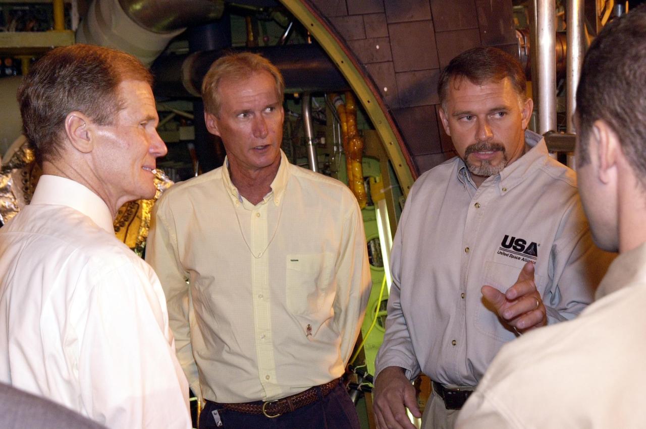 KENNEDY SPACE CENTER, FLA. -- U.S. Sen. Bill Nelson, left, talks to the Flow Liner Inspection & Repair team members, who are with United Space Alliance (USA). Nelson presented a gold seal Senate certificate to the team for their part in finding the cracks in orbiter flow liners and repairing them. On the right is David Strait, orbiter inspector, who first spotted the fuel-line crack. Second from the right is Jerry Goudy, welder, who performed arc welding on one of Atlantis' flow liners. Between Goudy and Nelson is Rick Beckwith, structural engineer.
