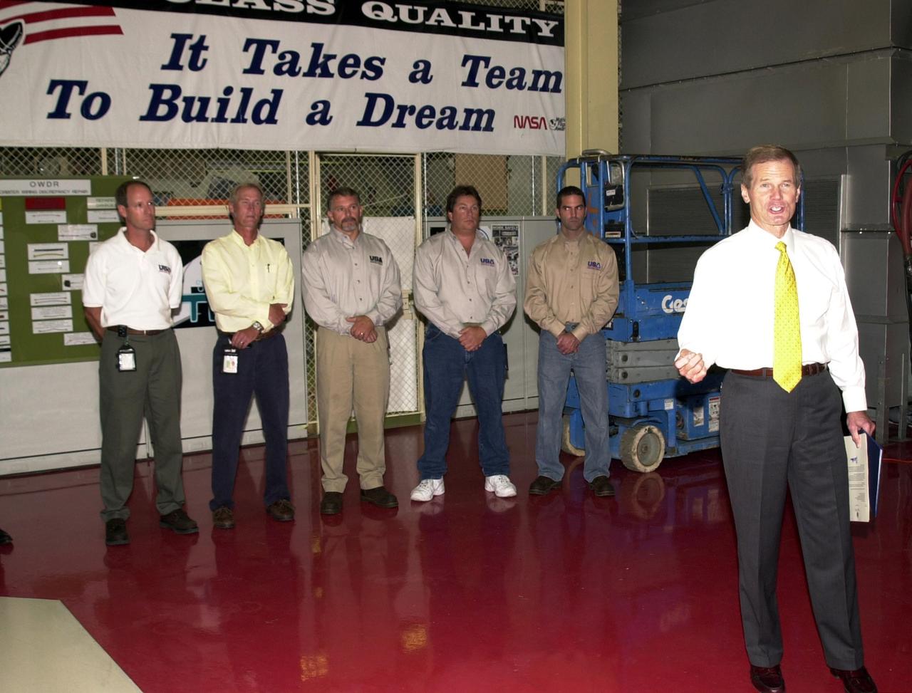 KENNEDY SPACE CENTER, FLA. - U.S. Sen. Bill Nelson (right) honors the Flow Liner Inspection & Repair team for their work on repairing the flow liners on the orbiters.   The team (background) comprises (left to right) Rick Beckwith, STR engineer; Mike Young, MPS engineer; Jerry Goudy, welder; Tony Nesotas, OFP-2 aft technician; and David Strait, OPF-2 orbiter inspector.  Strait first spotted the fuel-line crack; Goudy performed arc welding on one of Atlantis' flow liners.  Nelson presented gold seal Senate certificates to the team.  