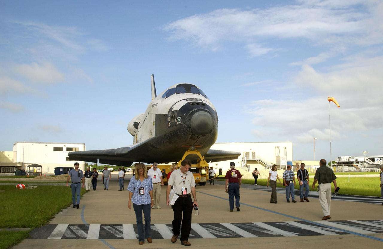 KENNEDY SPACE CENTER, FLA. -- Workers at KSC stroll along with the orbiter Atlantis as it rolls from the Orbiter Processing Facility to begin the next stage of preparation for launch. Atlantis will be making its 26th flight on mission STS-112, an assembly flight to the International Space Station. The orbiter will carry the first starboard truss segment, S1, which will be attached to the Central truss segment, the S0 Truss, on the Station. Atlantis is scheduled to launch no earlier than Oct. 2.