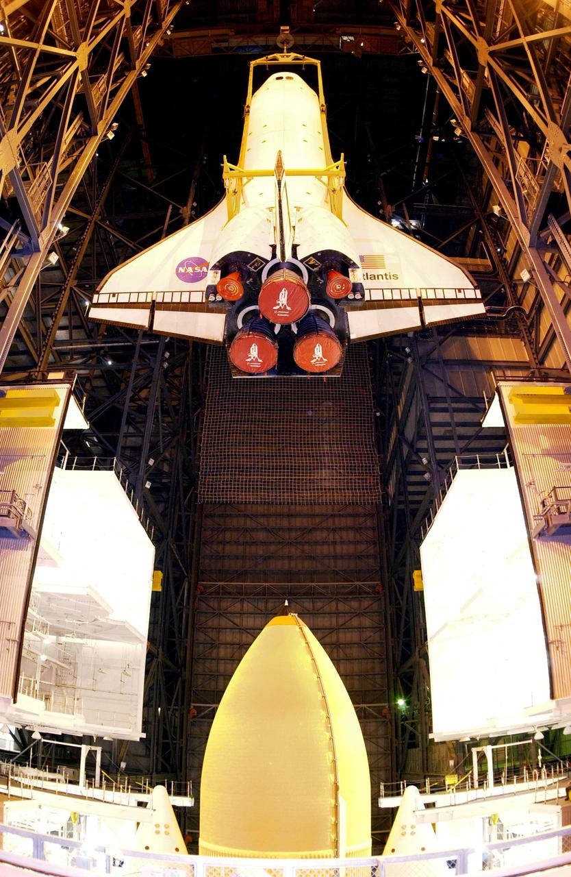 KENNEDY SPACE CENTER, FLA. -  Suspended from an overhead crane, the orbiter Atlantis is lowered toward the solid rocket booster and external tank below, on top of the Mobile Launcher Platform, for mating before rollout to the launch pad for mission STS-112.  Launch is scheduled no earlier than Oct. 2 for the 15th assembly flight to the International Space Station.  Atlantis will carry the S1 Integrated Truss Structure, which will be attached to the central truss segment, the S0 truss, during the mission.    