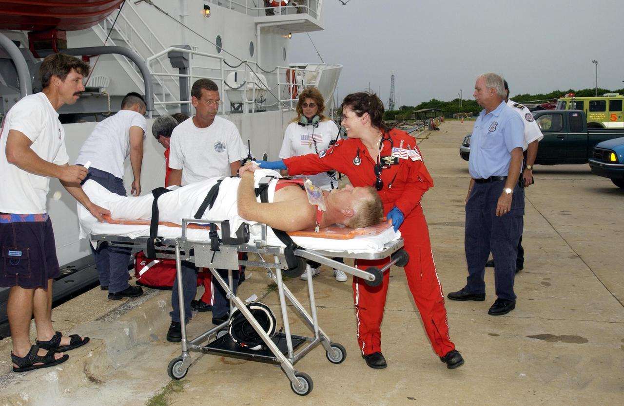 KENNEDY SPACE CENTER, FLA. - United Space Alliance workers on board the Freedom Star, one of the Shuttle Rocket Booster retrieval ships, release a distressed lobster diver to an Air Care Team from Orlando for transfer to a hospital.  The ship and its dive team, including a diver medical technician, Andy Fish, were instrumental in rescuing the diver off Cape Canaveral Sept. 11. The ship was on a certification exercise and near the location of a lobster diving boat that radioed the U.S. Coast Guard for help when one of the divers experienced difficulty breathing on his return to the surface.  Hearing the call for help, the captain of the Freedom Star offered to help. Fish stayed with the diver in the recompression chamber aboard the Freedom Star until the ship reached Port Canaveral where a KSC Occupational Health doctor waited.  The diver was stabilized and then taken to  Florida Hospital.  