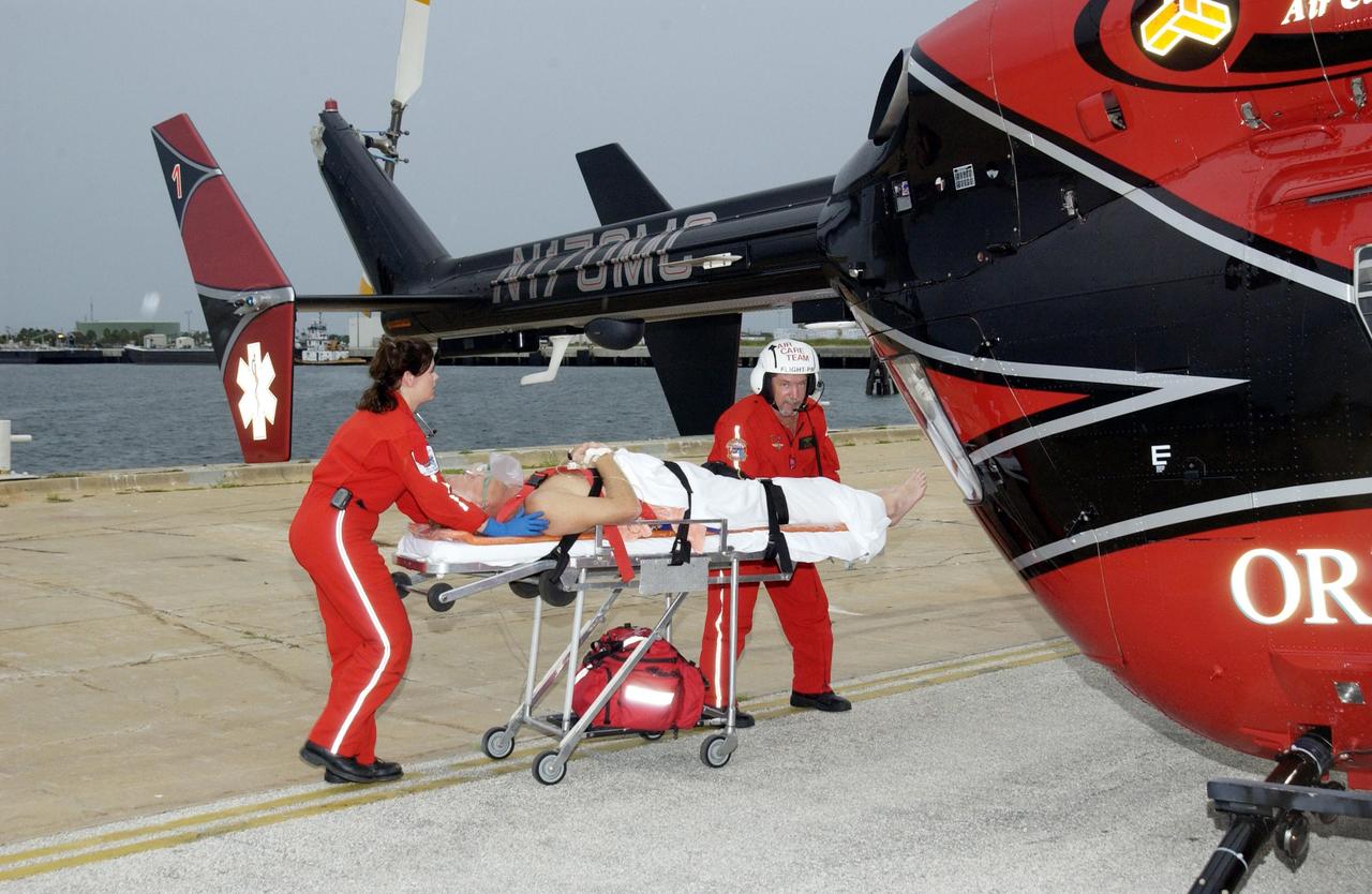 KENNEDY SPACE CENTER, FLA. --  An Air Care team from Orlando take a distressed lobster diver to the helicopter to take him to Florida Hospital.  The diver was picked up by the Freedom Star, one of the Shuttle Rocket Booster retrieval ships, on a certification exercise and near the location of a lobster diving boat that radioed the U.S. Coast Guard for help when one of the divers experienced difficulty breathing on his return to the surface.  Hearing the call for help, the captain of the Freedom Star offered to help.  The ship had a dive team on board, including a diver medical technician, Andy Fish, as well as a hyperbaric chamber. Fish stayed with the diver in the recompression chamber aboard the Freedom Star until the ship reached Port Canaveral where a KSC Occupational Health doctor waited.  The diver was stabilized and then taken to  Florida Hospital.