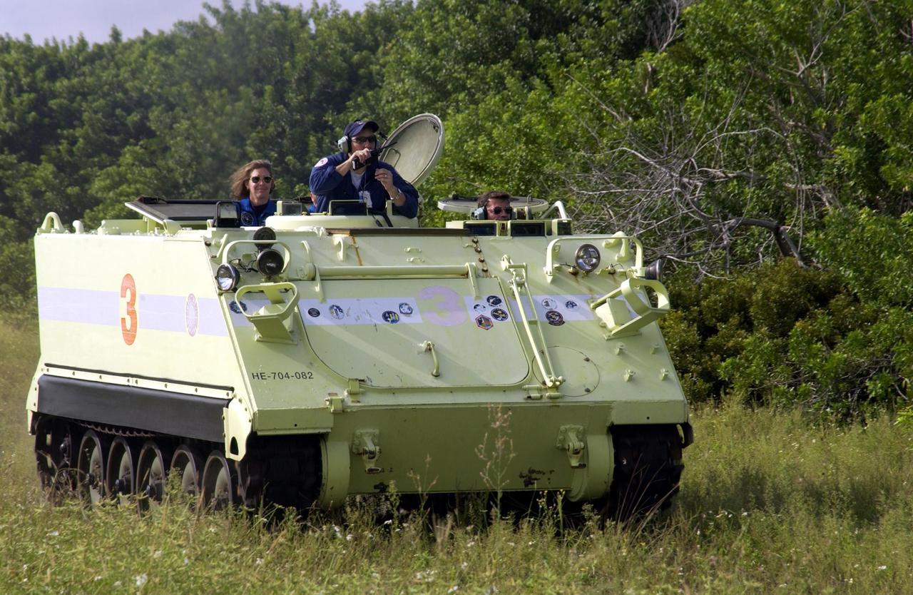 KENNEDY SPACE CENTER, Fla. -   STS-112 Commander Jeffrey Ashby drives the M-113 armored personnel carrier during Terminal Countdown Demonstration Test activities.  At the far left is Mission Specialist Sandra Magnus.    The TCDT also includes a simulated launch countdown.  The mission aboard Space Shuttle Atlantis is scheduled to launch no earlier than Oct. 2, between 2 and 6 p.m. EDT.  STS-112 is the 15th assembly mission to the International Space Station.  Atlantis will be carrying the S1 Integrated Truss Structure, the first starboard truss segment.  The S1 will be attached to the central truss segment, S0, during the 11-day mission.