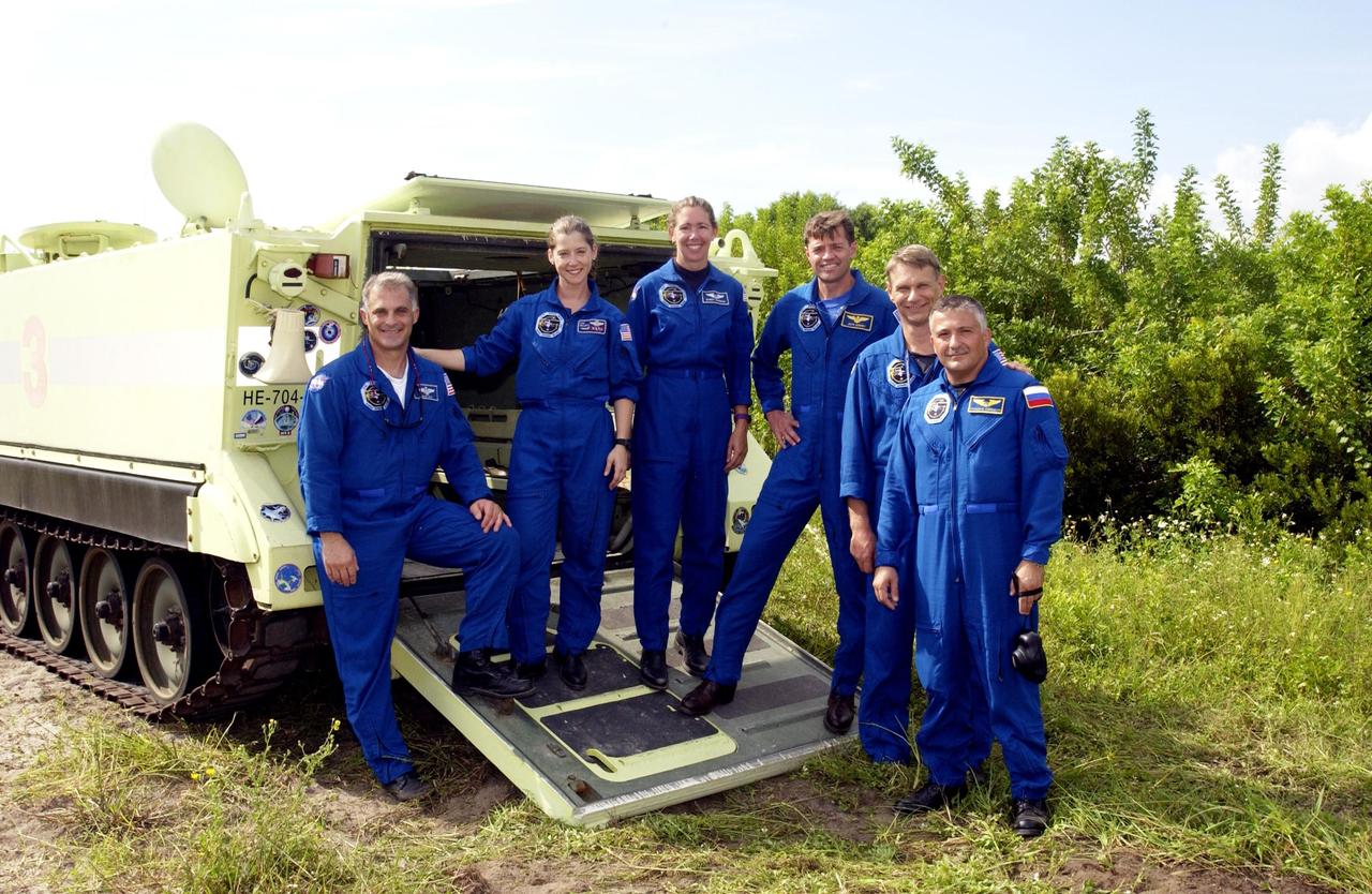 KENNEDY SPACE CENTER, Fla. -  The STS-112 crew poses for a photo on the back of the M-113 armored personnel carrier they practiced driving as part of Terminal Countdown Demonstration Test activities.  From left are Mission Specialist David Wolf, Pilot Pamela Melroy, Mission Specialist Sandra Magnus, Commander Jeffrey Ashby, and Mission Specialists Piers Sellers and Fyodor Yurchikhin, who is with the Russian Space Agency.  Mission STS-112 aboard Space Shuttle Atlantis is scheduled to launch no earlier than Oct. 2, between 2 and 6 p.m. EDT.  STS-112 is the 15th assembly mission to the International Space Station.  Atlantis will be carrying the S1 Integrated Truss Structure, the first starboard truss segment.  The S1 will be attached to the central truss segment, S0, during the 11-day mission.