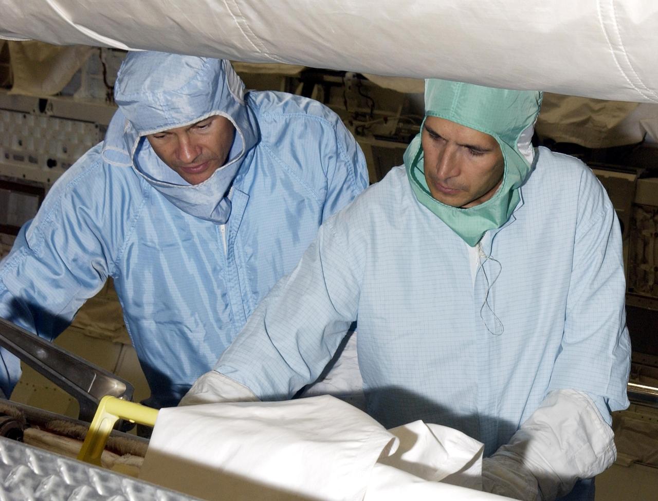 KENNEDY SPACE CENTER, FLA. -- As part of Crew Equipment Interface Test activities, STS-113 Mission Specialists Michael Lopez-Alegria (left) and John Herrington (right) practice working with flight equipment in Endeavour. The primary payloads on mission STS-113 are the first port truss segment, P1 Truss, to be attached to the central truss segment, S0, on the International Space Station, and the Crew and Equipment Translation Aid (CETA) Cart B that can be used by spacewalkers to move along the truss with equipment. Once delivered, the P1 truss will remain stowed until flight 12A.1. The mission will also deliver the Expedition 6 crew to the Station and return Expedition 5 to Earth. Space Shuttle Endeavour is scheduled to launch Nov. 10 on the 11-day mission.