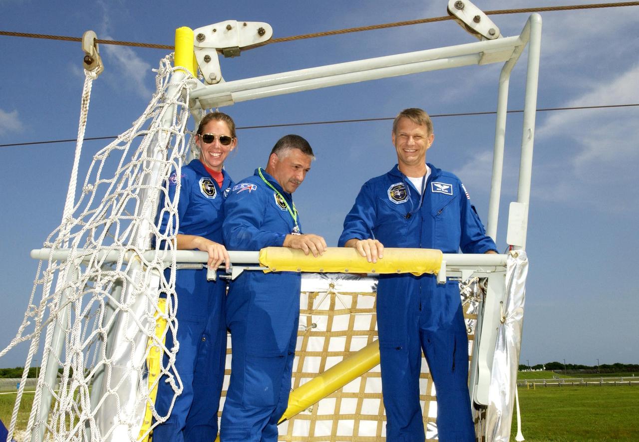 KENNEDY SPACE CENTER, FLA. --  Members of the STS-112 crew stand inside a slidewire basket, a component of the emergency egress system at the pad.  From left are Mission Specialists Sandra Magnus, Fyodor Yurchikhin (with the Russian Space Agency), and Piers Sellers. The training is part of Terminal Countdown Demonstration Test activities, which include a simulated launch countdown.  Mission STS-112 aboard Space Shuttle Atlantis is scheduled to launch no earlier than Oct. 2, between 2 and 6 p.m. EDT.  STS-112 is the 15th assembly mission to the International Space Station.  Atlantis will be carrying the S1 Integrated Truss Structure, the first starboard truss segment, to be attached to the central truss segment, S0, and the Crew and Equipment Translation Aid (CETA) Cart A.  The CETA is the first of two human-powered carts that will ride along the ISS railway, providing mobile work platforms for future spacewalking astronauts.  