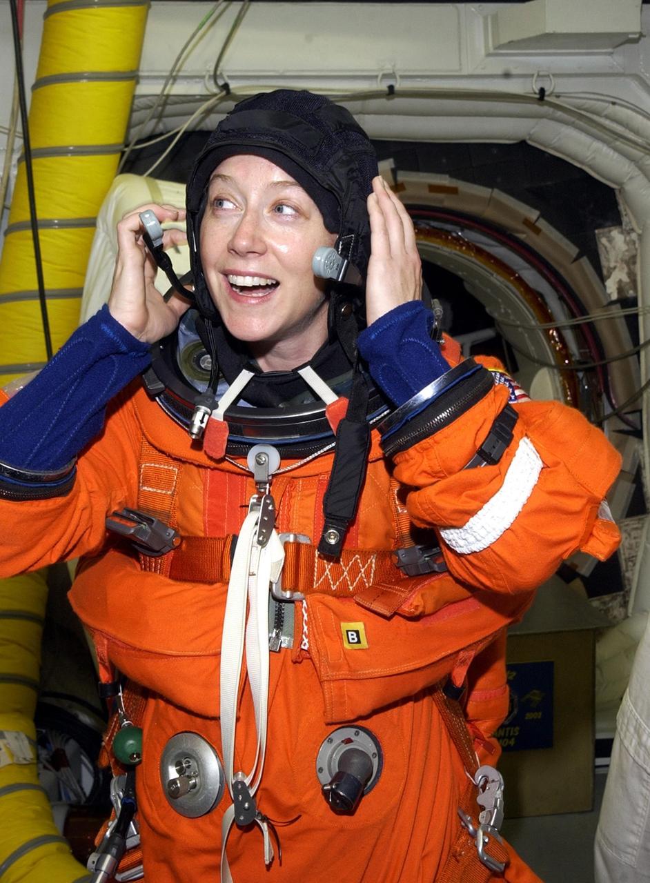 KENNEDY SPACE CENTER, FLA. -- In the White Room at Launch Pad 39B, STS-112  Pilot Pamela Melroy adjusts her spacesuit during a simulated launch countdown, part of Terminal Countdown Demonstration Test activities, a dress rehearsal for launch.  Launch of STS-112 aboard Space Shuttle Atlantis is scheduled for Oct. 2, between 2 and 6 p.m. EDT.  STS-112 is the 15th assembly mission to the International Space Station.  Atlantis will be carrying the S1 Integrated Truss Structure, the first starboard truss segment, which will be attached to the central truss segment, S0, and the Crew and Equipment Translation Aid (CETA) Cart A.  The CETA is the first of two human-powered carts that will ride along the ISS railway, providing mobile work platforms for future spacewalking astronauts.  
