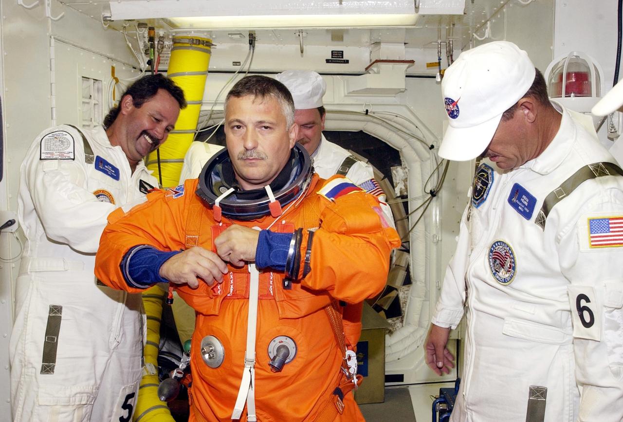 KENNEDY SPACE CENTER, FLA. -- In the White Room at Launch Pad 39B, STS-112  Mission Specialist Fyodor Yurchikhin, Ph.D., a cosmonaut with the Russian Space Agency, receives assistance with his spacesuit during a simulated launch countdown, part of Terminal Countdown Demonstration Test activities, a dress rehearsal for launch.  Launch of STS-112 aboard Space Shuttle Atlantis is scheduled for Oct. 2, between 2 and 6 p.m. EDT.  STS-112 is the 15th assembly mission to the International Space Station.  Atlantis will be carrying the S1 Integrated Truss Structure, the first starboard truss segment, which will be attached to the central truss segment, S0, and the Crew and Equipment Translation Aid (CETA) Cart A.  The CETA is the first of two human-powered carts that will ride along the ISS railway, providing mobile work platforms for future spacewalking astronauts.  