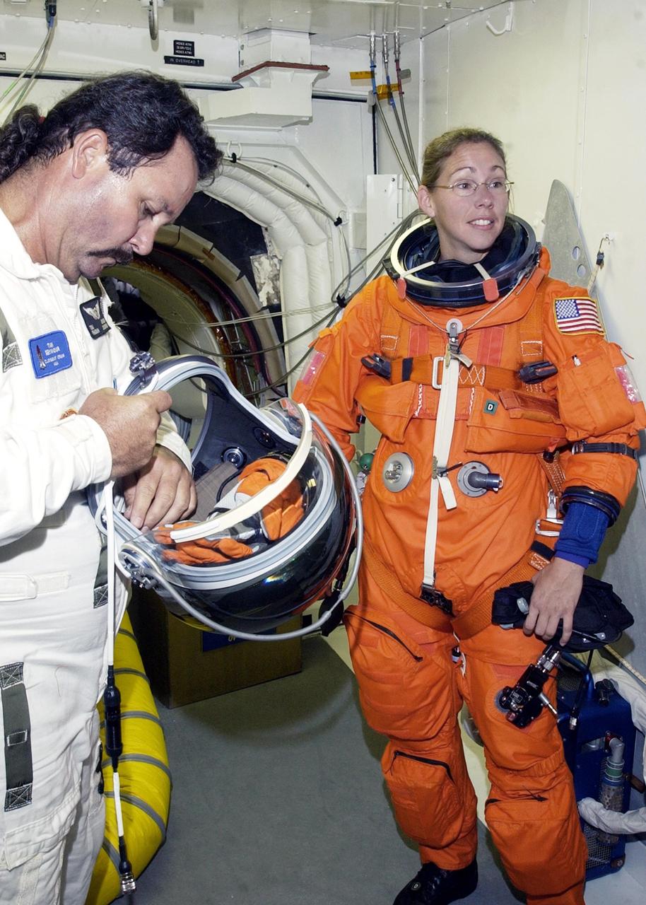 KENNEDY SPACE CENTER, FLA. -- In the White Room at Launch Pad 39B, STS-112  Mission Specialist Sandra Magnus, Ph.D., receives assistance with her spacesuit during a simulated launch countdown, part of Terminal Countdown Demonstration Test activities, a dress rehearsal for launch.  Launch of STS-112 aboard Space Shuttle Atlantis is scheduled for Oct. 2, between 2 and 6 p.m. EDT.  STS-112 is the 15th assembly mission to the International Space Station.  Atlantis will be carrying the S1 Integrated Truss Structure, the first starboard truss segment, which will be attached to the central truss segment, S0, and the Crew and Equipment Translation Aid (CETA) Cart A.  The CETA is the first of two human-powered carts that will ride along the ISS railway, providing mobile work platforms for future spacewalking astronauts.  