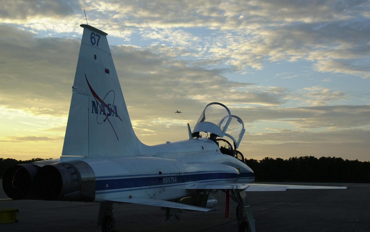KENNEDY SPACE CENTER, FLA. --Framed by a T-38 on the Shuttle Landing Facility, the Shuttle Training Aircraft can be seen in the distance against the sunset.  Commander Jeffrey Ashby and Pilot Pamela Melroy are going through landing exercises on the SLF.