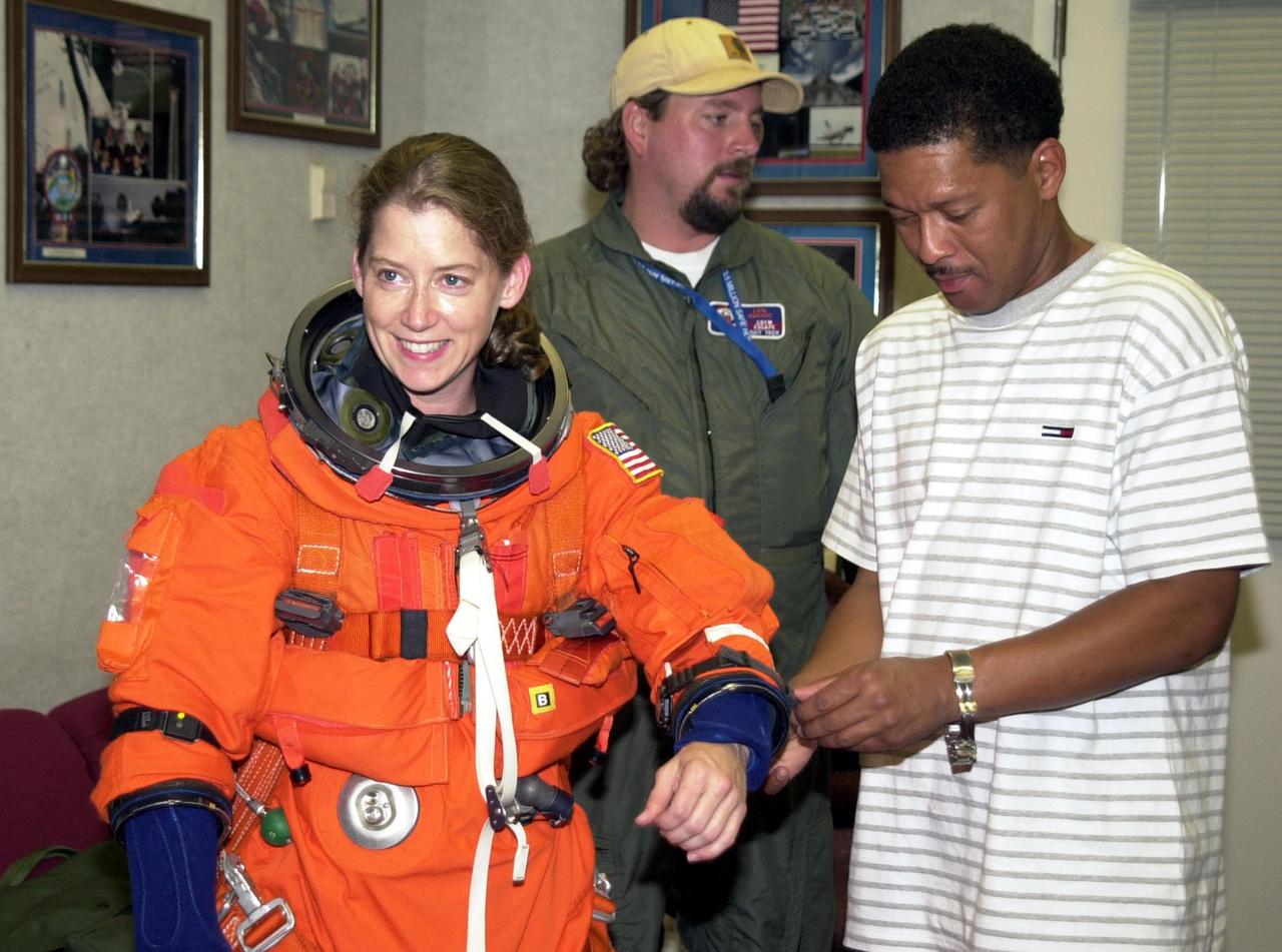 KENNEDY SPACE CENTER, FLA. --STS-112 Pilot Pamela Melroy receives some assistance with her spacesuit as she prepares to participate in landing exercises in the Shuttle Training Aircraft at the Shuttle Landing Facility.
