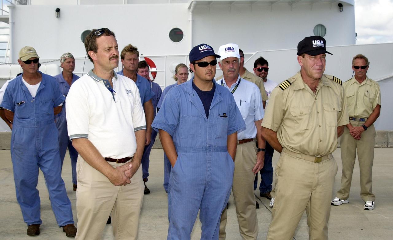 KENNEDY SPACE CENTER, FLA. -   A reunion at the Hangar AF docks, Cape Canaveral Air Force Station, brought together a diver and his rescuers, the crew of KSC's Freedom Star SRB retrieval ship and a medical team.  In the photo are (foreground, left to right) KSC Occupational Health physician Skip Beeler, retrieval diver and diver medical technician Andy Fish, and Freedom Star's Captain, Dave Fraine.  The diver, Jack Wilcox, suffered decompression sickness on a diving expedition 20 miles off shore in the Atlantic Ocean.  When the Freedom Star team heard the call for help, they asked the Coast Guard if they could assist. The ship was out on a crane certification exercise and coincidentally had a diver medical technician and other divers training on the crane. The ship's divers were trained for the hyperbaric chamber on board. Upon reaching the Army dock, KSC Occupational Health physician Skip Beeler entered the chamber and continued the process of helping to stabilize Wilcox. After several hours in the chamber, Wilcox, who lives in Orlando, was airlifted to Florida Hospital Orlando