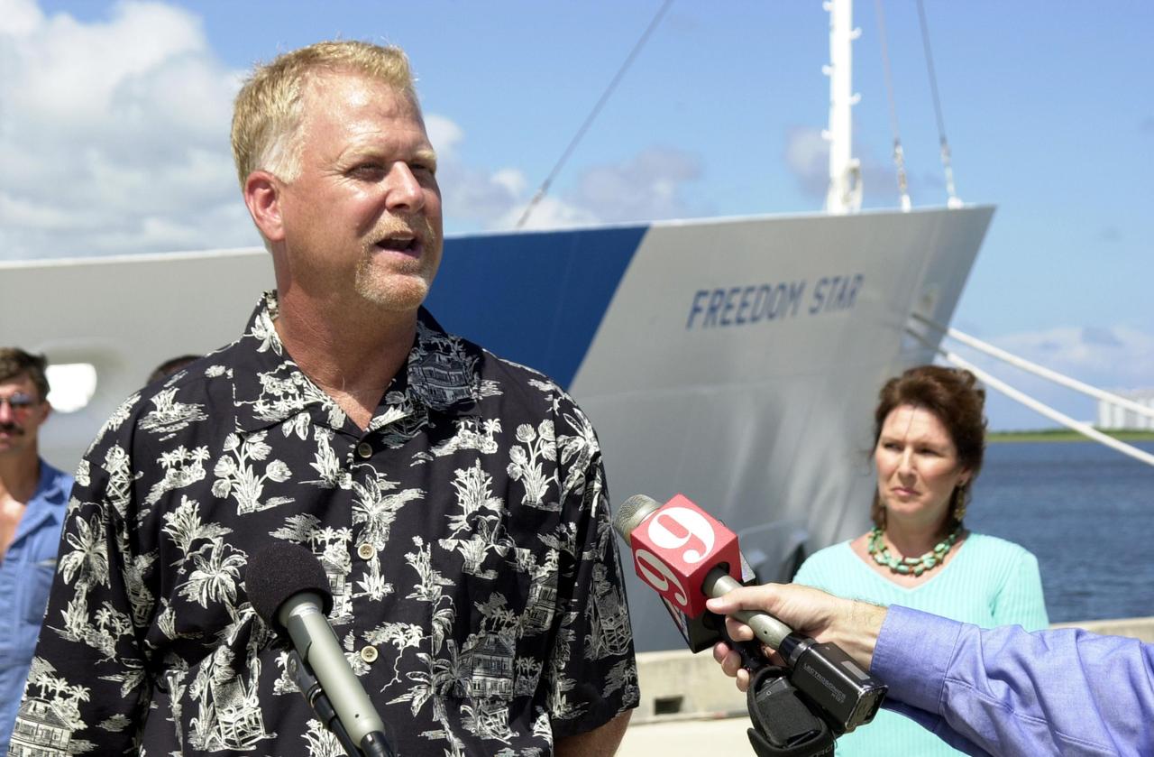 KENNEDY SPACE CENTER, FLA. - KENNEDY SPACE CENTER, FLA. - Jack Wilcox answers questions from the media during a reunion at the Hangar AF docks, Cape Canaveral Air Force Station, with his rescuers.  At right is his wife, Patty.  Wilcox reunited with the men aboard KSC's Freedom Star SRB retrieval ship that was in the vicinity when Wilcox suffered decompression sickness on a diving expedition 20 miles off shore in the Atlantic Ocean. When the Freedom Star team heard the call for help, they asked the Coast Guard if they could assist. The ship was out on a crane certification exercise and coincidentally had a diver medical technician and other divers training on the crane. The ship's divers were trained for the hyperbaric chamber on board.  Upon reaching the Army dock, KSC Occupational Health physician Skip Beeler entered the chamber and continued the process of helping to stabilize Wilcox. After several hours in the chamber, Wilcox, who lives in Orlando, was airlifted to Florida Hospital Orlando.