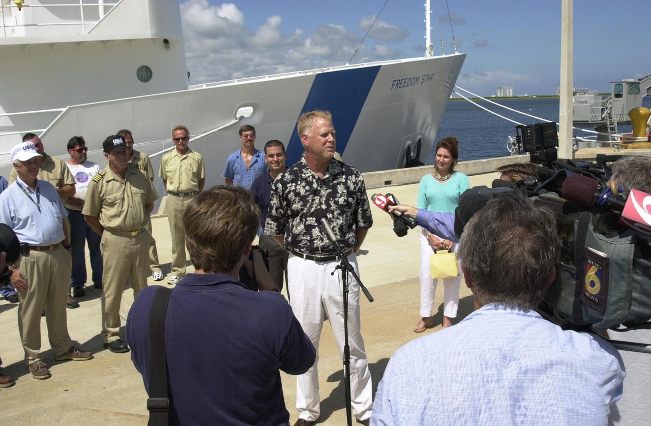 KENNEDY SPACE CENTER, FLA. - Jack Wilcox (at the microphone) answers questions from the media during a reunion with his rescuers at the Hangar AF docks, Cape Canaveral Air Force Station.  At right is his wife, Patty.  Wilcox reunited with the men aboard KSC's Freedom Star SRB retrieval ship that was in the vicinity when Wilcox suffered decompression sickness on a diving expedition 20 miles off shore in the Atlantic Ocean. When the Freedom Star team heard the call for help, they asked the Coast Guard if they could assist. The ship was out on a crane certification exercise and coincidentally had a diver medical technician and other divers training on the crane. The ship's divers were trained for the hyperbaric chamber on board.  Upon reaching the Army dock, KSC Occupational Health physician Skip Beeler entered the chamber and continued the process of helping to stabilize Wilcox. After several hours in the chamber, Wilcox, who lives in Orlando, was airlifted to Florida Hospital Orlando.