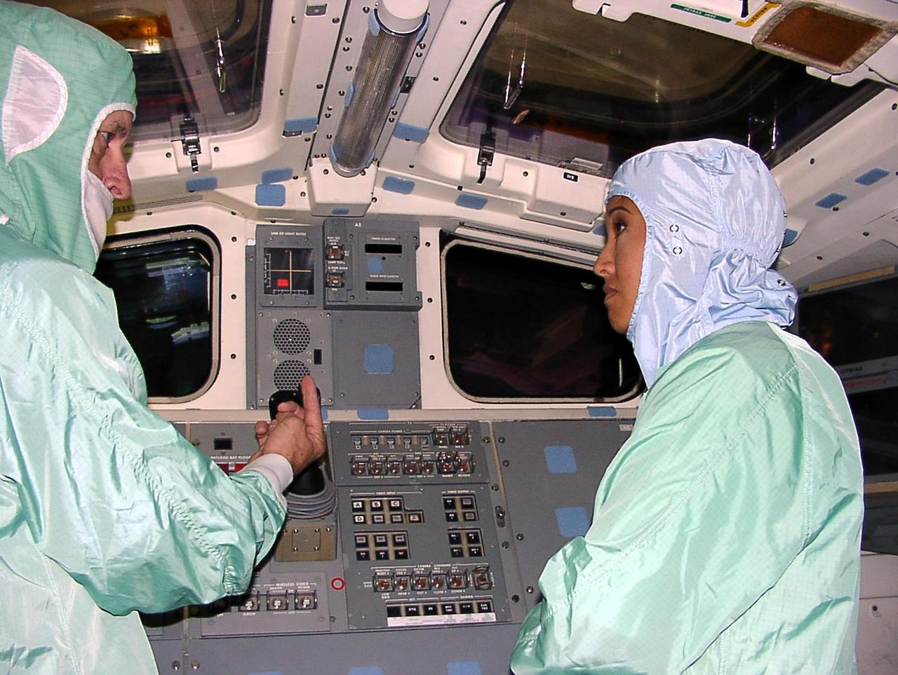 KENNEDY SPACE CENTER, FLA. -- WESH-TV 2 News Anchor Wendy Chioji (right) is given a briefing on how to pilot a Space Shuttle orbiter during a tour inside the cockpit of an orbiter. Chioji was at KSC to speak at the 2002 Combined Federal Campaign (CFC) kickoff rally.