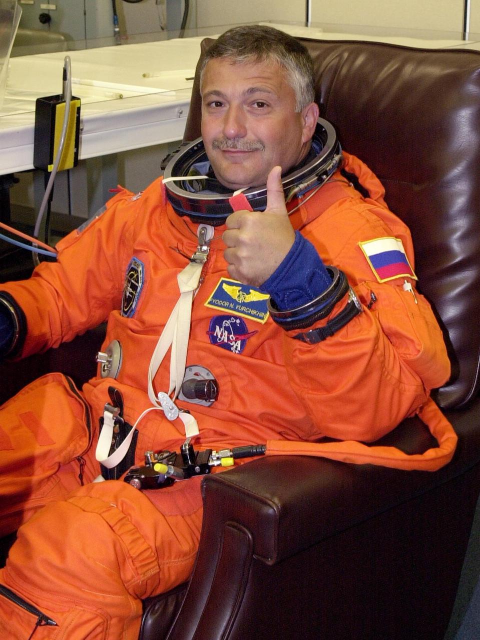 KENNEDY SPACE CENTER, FLA. -- During suitup for launch, STS-112 Mission Specialist Fyodor Yurchikhin shows he is ready for his first Shuttle flight. STS-112 is the 15th assembly flight to the International Space Station, carrying the S1 Integrated Truss Structure, the first starboard truss segment, to be attached to the central truss segment, S0, and the Crew and Equipment Translation Aid (CETA) Cart A. The CETA is the first of two human-powered carts that will ride along the ISS railway, providing mobile work platforms for future spacewalking astronauts. On the 11-day mission, three spacewalks are planned to attach the S1 truss. Launch is scheduled for 3:46 p.m. EDT from Launch Pad 39B.