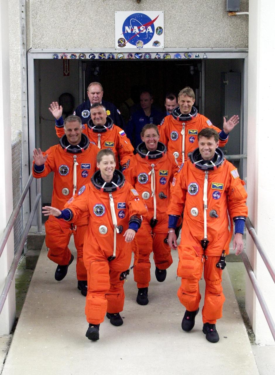KENNEDY SPACE CENTER, FLA. -- The STS-112 crew wave to spectators as they exit the Operations and Checkout Building for their ride to Launch Pad 39B and the launch scheduled 3:46 p.m. EDT.  Leading the way are Pilot Pamela Melroy and Commander Jeffrey Ashby.  In the second row are Mission Specialists David Wolf (left) and Sandra Magnus.  Behind them are Mission Specialists Fyodor Yurchikhin and Piers Sellers.  Sellers, Magnus and Yurchikhin are making their first Shuttle flights. STS-112 is the 15th assembly flight to the International Space Station, carrying the S1 Integrated Truss Structure, the first starboard truss segment, to be attached to the central truss segment, S0, and the Crew and Equipment Translation Aid (CETA) Cart A.  The CETA is the first of two human-powered carts that will ride along the ISS railway, providing mobile work platforms for future spacewalking astronauts.  On the 11-day mission, three spacewalks are planned to attach the S1 truss to the Station. 