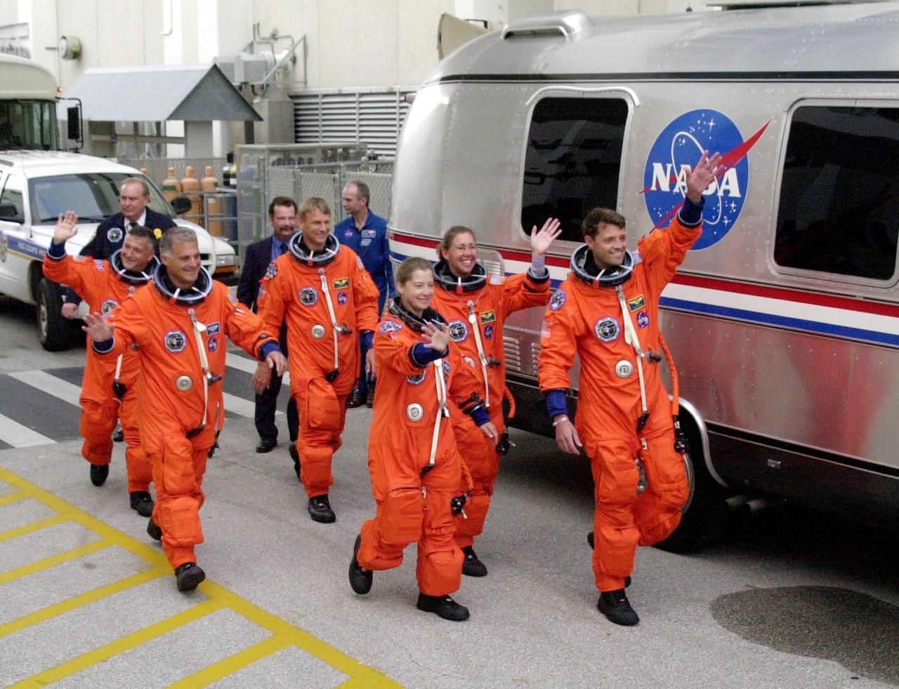 KENNEDY SPACE CENTER, FLA. -- Still waving at spectators, the STS-112 crew heads for the Astrovan that will take them to Launch Pad 39B and Space Shuttle Atlantis. Liftoff is scheduled for 3:46 p.m. EDT. From left are Mission Specialists Fyodor Yurchikhin David Wolf, and Piers Sellers; Pilot Pamela Melroy; Mission Specialist Sandra Magnus; and Commander Jeffrey Ashby. Sellers, Magnus and Yurchikhin are making their first Shuttle flights. STS-112 is the 15th assembly flight to the International Space Station, carrying the S1 Integrated Truss Structure, the first starboard truss segment, to be attached to the central truss segment, S0, and the Crew and Equipment Translation Aid (CETA) Cart A. The CETA is the first of two human-powered carts that will ride along the ISS railway, providing mobile work platforms for future spacewalking astronauts. On the 11-day mission, three spacewalks are planned to attach the S1 truss to the Station.
