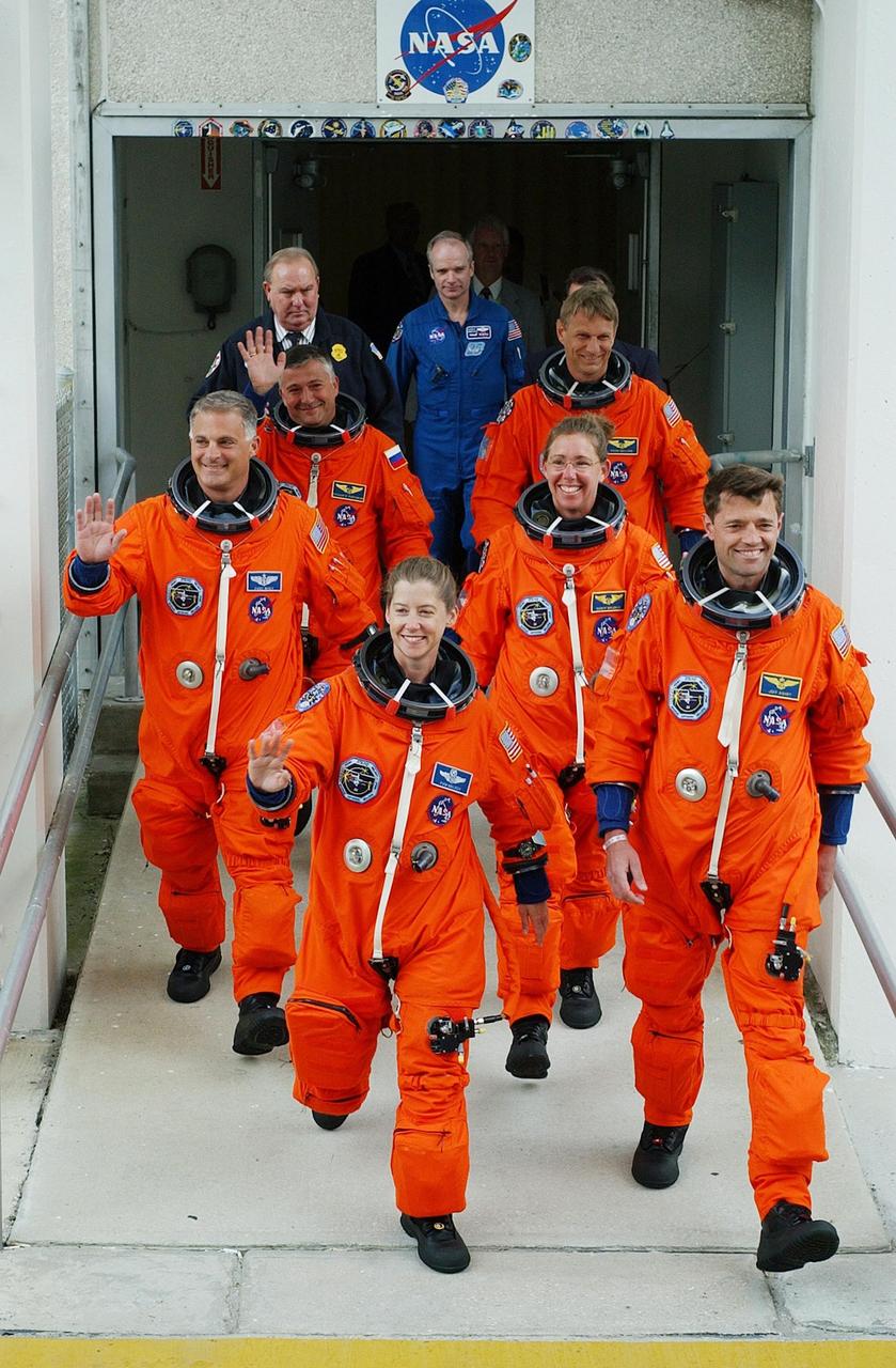 KENNEDY SPACE CENTER, FLA. --  The STS-112 crew eagerly exit the Operations and Checkout Building for their ride to Launch Pad 39B and the launch scheduled 3:46 p.m. EDT.  Leading the way are Pilot Pamela Melroy and Commander Jeffrey Ashby.  In the second row are Mission Specialists David Wolf (left) and Sandra Magnus.  Behind them are Mission Specialists Fyodor Yurchikhin and Piers Sellers.  Sellers, Magnus and Yurchikhin are making their first Shuttle flights. STS-112 is the 15th assembly flight to the International Space Station, carrying the S1 Integrated Truss Structure, the first starboard truss segment, to be attached to the central truss segment, S0, and the Crew and Equipment Translation Aid (CETA) Cart A.  The CETA is the first of two human-powered carts that will ride along the ISS railway, providing mobile work platforms for future spacewalking astronauts.  On the 11-day mission, three spacewalks are planned to attach the S1 truss to the Station.   [Photo courtesy of Scott Andrews]