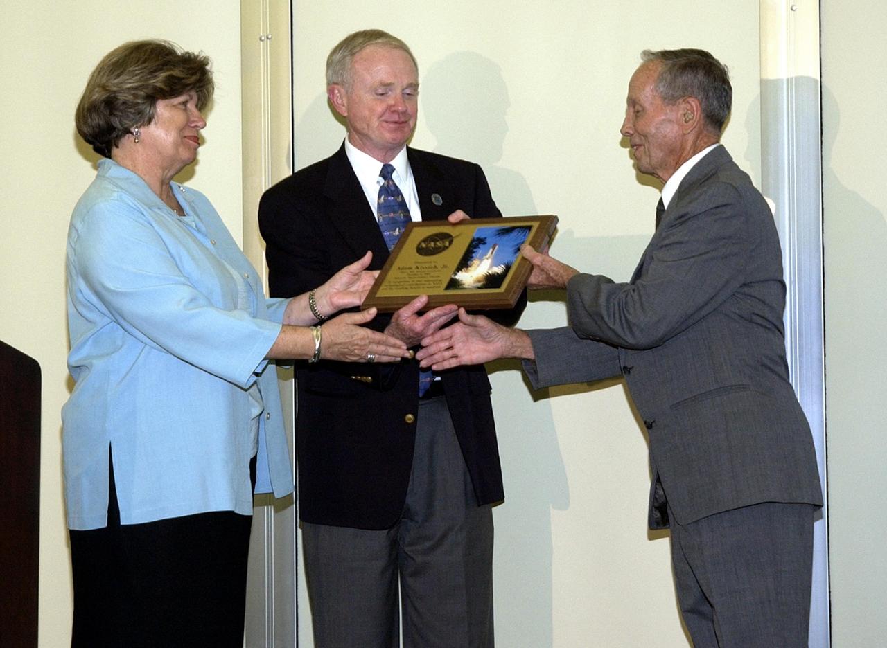KENNEDY SPACE CENTER, FLA. - Adam Kissiah (right), a retired NASA-KSC engineer and inventor of a cochlear implant, receives an exceptional category NASA Space Act Award for his 25-year-old technology breakthrough during a technology awards luncheon held at the KSC Visitor Complex Debus Center. Presenting the award are, from left, Acting Deputy Center Director JoAnn Morgan, Center Director Roy Bridges, and Kissiah.  The award included a monetary award and a certificate signed by the NASA Administrator. Space Act Awards provide official recognition and grant equitable monetary awards for inventions and scientific and technical contributions that have helped achieve NASA's aeronautical and space goals.  