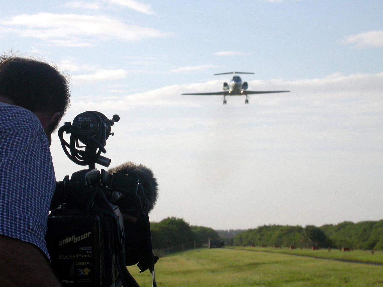 KENNEDY SPACE CENTER, FLA. --  At the Shuttle Landing Facility, KSC videographer Glen Benson films with HDTV the Shuttle Training Aircraft (STA) preparing to land. The STA is a modified Grumman Gulfstream II aircraft with an onboard special computer system to enable the aircraft to simulate the orbiter.    [Photo by Walt Lindblom, Marshall SFC]
