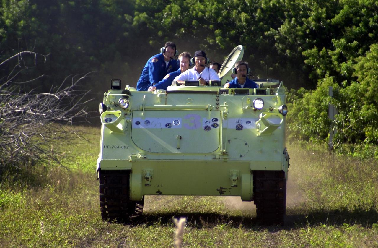 KENNEDY SPACE CENTER, FLA. -- STS-113 Pilot Paul Lockhart test drives an M-113 armored personnel carrier, part of emergency egress training during Terminal Countdown Demonstration Test activities. He is accompanied by several other crew members, seen at left, Mission Specialist Michael Lopez-Alegria and Commander James Wetherbee. The crew is preparing for the mission aboard Space Shuttle Endeavour, which is scheduled to launch Nov. 10. The TCDT includes a simulated launch countdown. The primary payloads on mission STS-113 are the first port truss segment, P1, and the Crew and Equipment Translation Aid (CETA) Cart B. Once delivered, the P1 truss will remain stowed until flight 12A.1 in 2003 when it will be attached to the central truss segment, S0, on the Space Station. Also onboard Space Shuttle Endeavour will be the Expedition 6 crew who will replace Expedition 5, returning to Earth after 4 months.