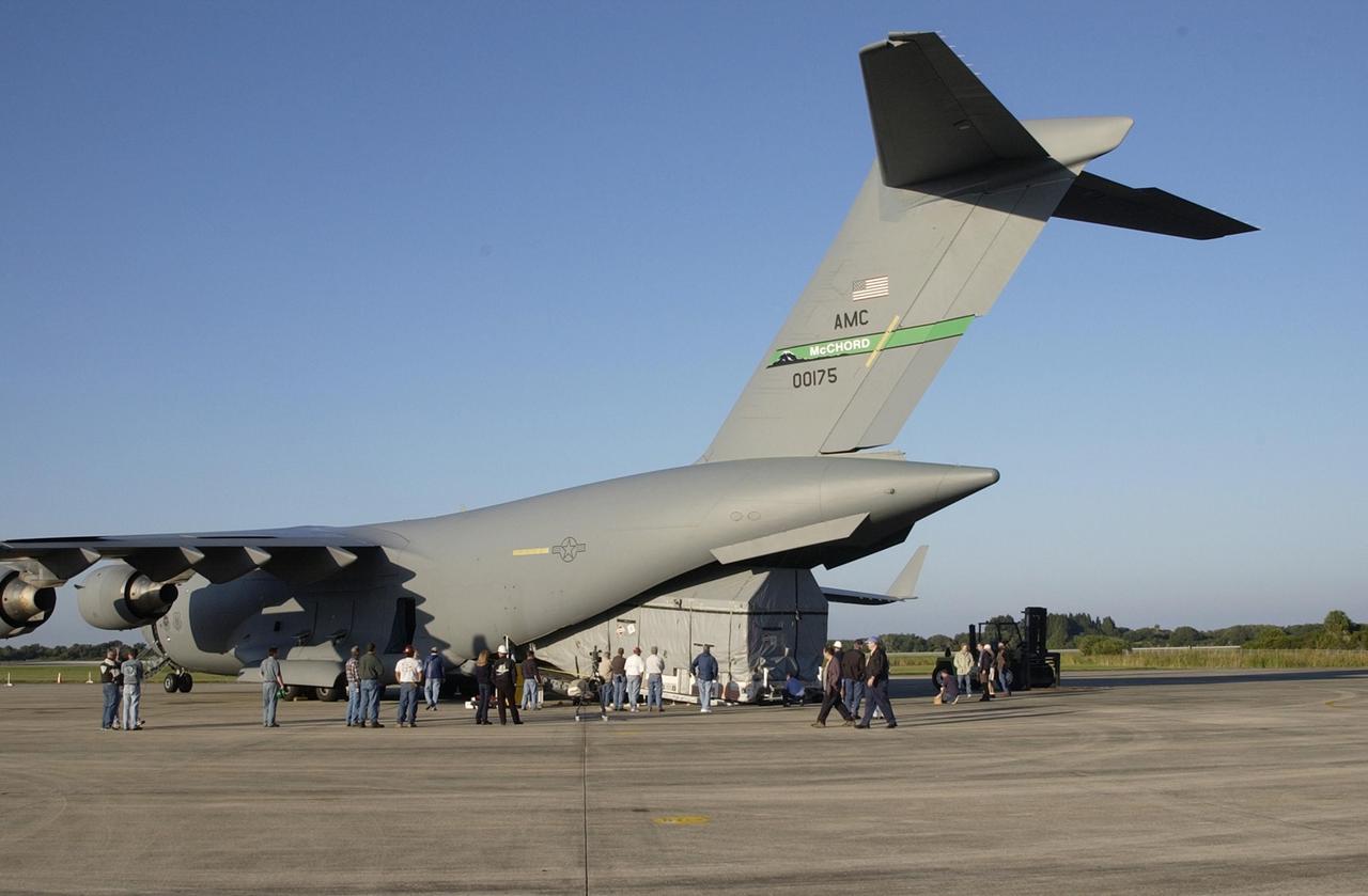 KENNEDY SPACE CENTER, FLA. --  The Tracking and Data Relay Satellite-J (TDRS-J) is offloaded  at the KSC Shuttle Landing Facility from an Air Force C-17 air cargo plane.   It will be transferred to the Spacecraft Assembly and Encapsulation Facility-2 (SAEF-2). TDRS-J weighs 3,338 pounds, but at launch will weigh 7,031 pounds when fully fueled with its propellants consisting of monomethylhydrazine fuel and nitrogen tetroxide oxidizer. The solar arrays, when deployed, will supply the spacecraft with up to 2,200 watts of power.  TDRS-J is the third in the current series of three Tracking and Data Relay Satellites designed to replenish the existing on-orbit fleet of six spacecraft, the first of which was launched in 1983. The Tracking and Data Relay Satellite System is the primary source of space-to-ground voice, data and telemetry for the Space Shuttle. It also provides communications with the International Space Station and scientific spacecraft in low-earth orbit such as the Hubble Space Telescope, and launch support for some expendable vehicles. This new advanced series of satellites will extend the availability of TDRS communications services until approximately 2017.  