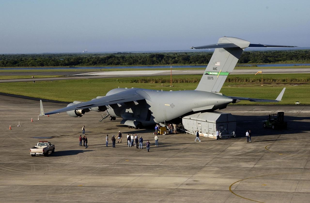 KENNEDY SPACE CENTER, FLA. --  The Tracking and Data Relay Satellite-J (TDRS-J) has been offloaded at the KSC Shuttle Landing Facility from an Air Force C-17 air cargo plane.   It will be transferred to the Spacecraft Assembly and Encapsulation Facility-2 (SAEF-2). TDRS-J weighs 3,338 pounds, but at launch will weigh 7,031 pounds when fully fueled with its propellants consisting of monomethylhydrazine fuel and nitrogen tetroxide oxidizer. The solar arrays, when deployed, will supply the spacecraft with up to 2,200 watts of power.  TDRS-J is the third in the current series of three Tracking and Data Relay Satellites designed to replenish the existing on-orbit fleet of six spacecraft, the first of which was launched in 1983. The Tracking and Data Relay Satellite System is the primary source of space-to-ground voice, data and telemetry for the Space Shuttle. It also provides communications with the International Space Station and scientific spacecraft in low-earth orbit such as the Hubble Space Telescope, and launch support for some expendable vehicles. This new advanced series of satellites will extend the availability of TDRS communications services until approximately 2017.  