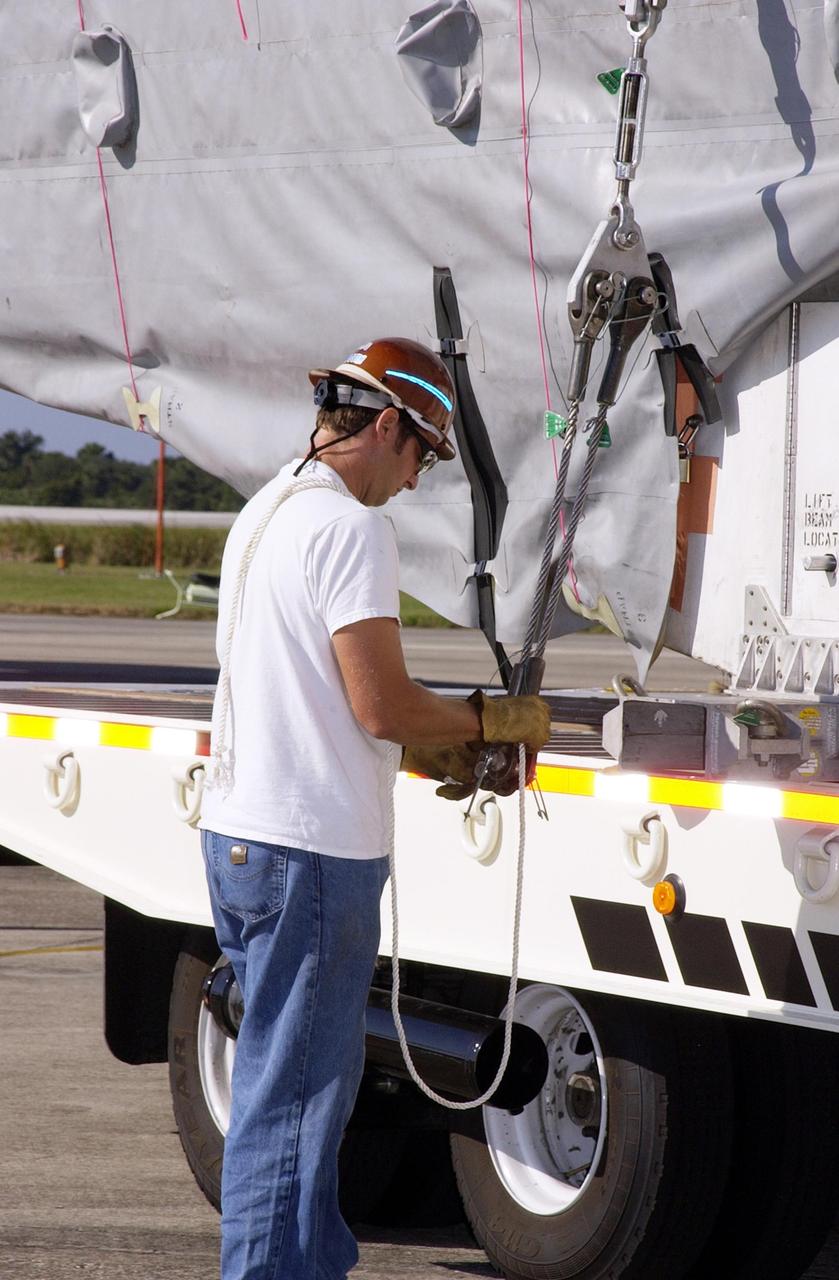 KENNEDY SPACE CENTER, FLA. -  A worker ties down the container with the TDRS-J spacecraft onto a transport vehicle. TDRS-J is the third in the current series of three Tracking and Data Relay Satellites designed to replenish the existing on-orbit fleet of six spacecraft, the first of which was launched in 1983. The Tracking and Data Relay Satellite System is the primary source of space-to-ground voice, data and telemetry for the Space Shuttle. It also provides communications with the International Space Station and scientific spacecraft in low-earth orbit such as the Hubble Space Telescope, and launch support for some expendable vehicles. This new advanced series of satellites will extend the availability of TDRS communications services until approximately 2017. 
