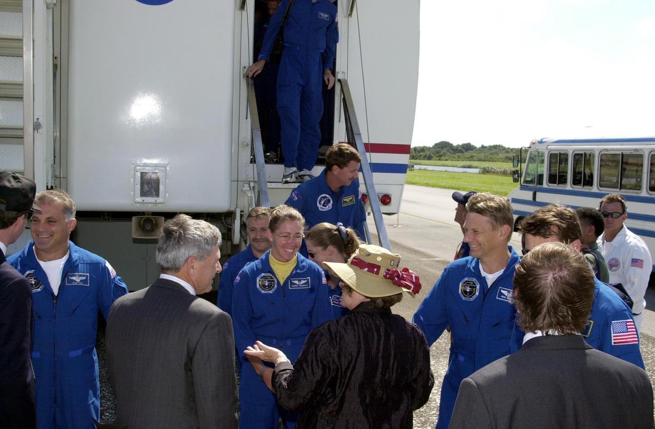 KENNEDY SPACE CENTER, FLA. --  As the STS-112 crew leaves the crew transport vehicle, they are greeted by mission managers and guests.  The crew, from left, are Mission Specialists David Wolf, Fyodor Yurchikhin and Sandra Magnus; Pilot Pamela Melroy; Piers Sellers (talking to Acting Deputy Director JoAnn Morgan) and Commander Jeffrey Ashby (talking to Launch Director Mike Leinbach).  Morgan is also Director of External Relations and Business Development.  The crew returned to KSC after completing a 4.5-million-mile journey to the International Space Station.  Main gear touchdown occurred at 11:43:40 a.m. EDT; nose gear touchdown at 11:43:48 a.m.; and wheel stop at 11:44:35 a.m.  Mission elapsed time was 10:19:58:44.  Mission STS-112 expanded the size of the Station with the addition of the S1 truss segment.           .    