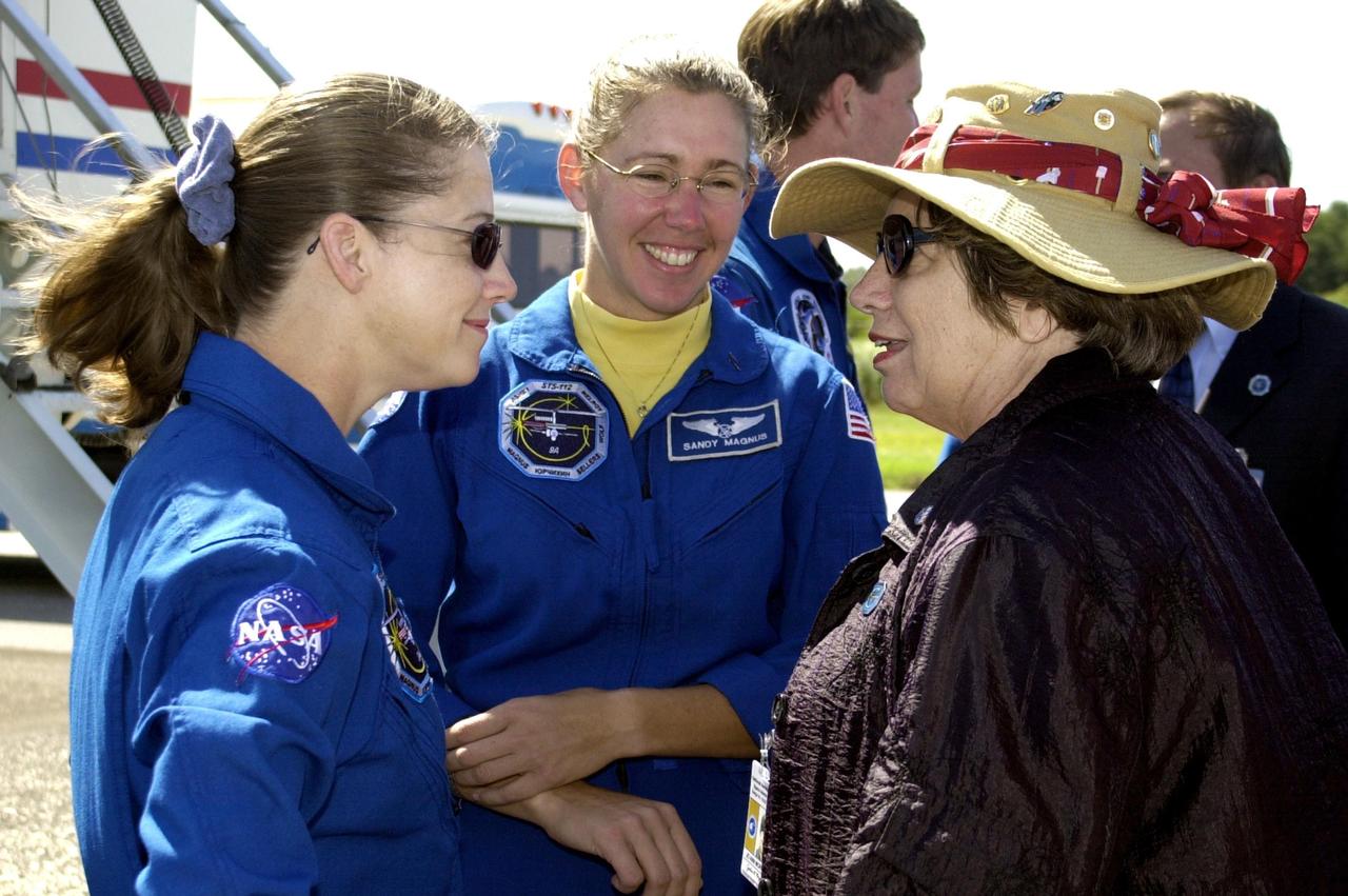 KENNEDY SPACE CENTER, FLA. --  STS-112 Pilot Pamela Melroy (left) and Mission Specialist Sandra Magnus (center) talk to Acting Deputy Director JoAnn Morgan (right) after the crew's return to KSC.  A flawless landing of Space Shuttle Atlantis completed a 4.5-million-mile journey to the International Space Station.  Other crew members are Commander Jeffrey Ashby and Mission Specialists David Wolf, Fyodor Yurchikhin and Piers Sellers.  Main gear touchdown occurred at 11:43:40 a.m. EDT; nose gear touchdown at 11:43:48 a.m.; and wheel stop at 11:44:35 a.m.  Mission elapsed time was 10:19:58:44.  Mission STS-112 expanded the size of the Station with the addition of the S1 truss segment.  