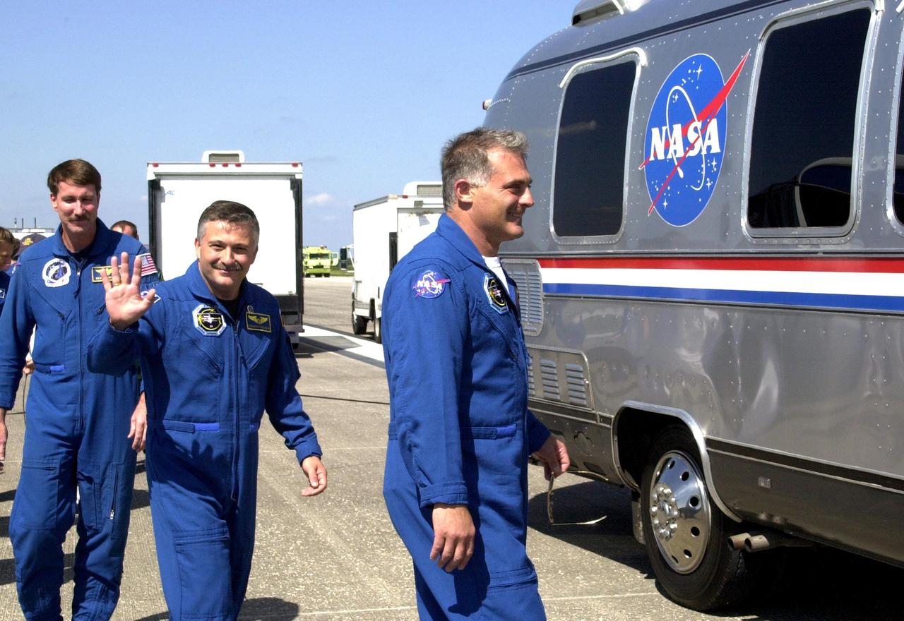 KENNEDY SPACE CENTER, FLA. -  Accompanied by astronaut Kent Rominger (far left), STS-112 crew members head for the Astrovan after exiting the crew transport vehicle and greeting the spectators.  In the center is Mission Specialist Fyodor Yurchikhin; at right is Mission Specialist David Wolf.  The flawless landing of Atlantis on Runway 33 at KSC completed a 4.5-million-mile journey to the International Space Station. Main gear touchdown occurred at 11:43:40 a.m. EDT; nose gear touchdown at 11:43:48 a.m.; and wheel stop at 11:44:35 a.m.  Mission elapsed time was 10:19:58:44.  Mission STS-112 expanded the size of the Station with the addition of the S1 truss segment. 