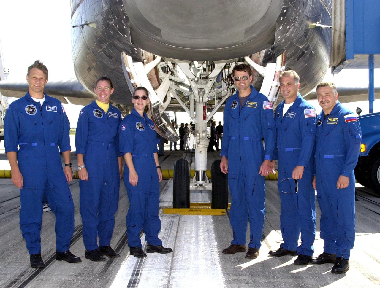 KENNEDY SPACE CENTER, FLA. --  After a flawless landing on runway 33 of the Shuttle Landing Facility, the STS-112 crew poses in front of Atlantis.  From left are Mission Specialists Piers Sellers and Sandra Magnus, Pilot Pamela Melroy, Commander Jeffrey Ashby, and Mission Specialists David Wolf and Fyodor Yurchikhin, who represents the Russian Space Agency. Main gear touchdown occurred at 11:43:40 a.m. EDT; nose gear touchdown at 11:43:48 a.m.; and wheel stop at 11:44:35 a.m. Mission elapsed time was 10:19:58:44.  STS-112 expanded the size of the Station with the addition of the S1 truss segment.  