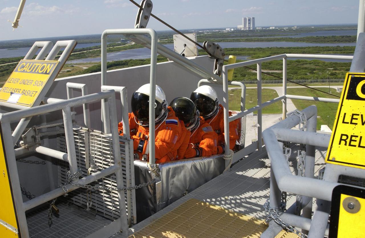KENNEDY SPACE CENTER, FLA. --  The Expedition 6 crew practice emergency egress from the 195-foot level of the Fixed Service Structure on Launch Pad 39A.  In the slidewire basket are (from left) cosmonaut Nikolai Budarin, astronaut Donald Pettit and Commander Ken Bowersox.  The crew, travelers on Mission STS-113, will be replacing Expedition 5 on the International Space Station.   Along with Expedition 6, STS-113 will carry the Port 1 (P1) truss aboard Space Shuttle Endeavour.   Mission STS-113 is scheduled to launch Nov. 10, 2002.  