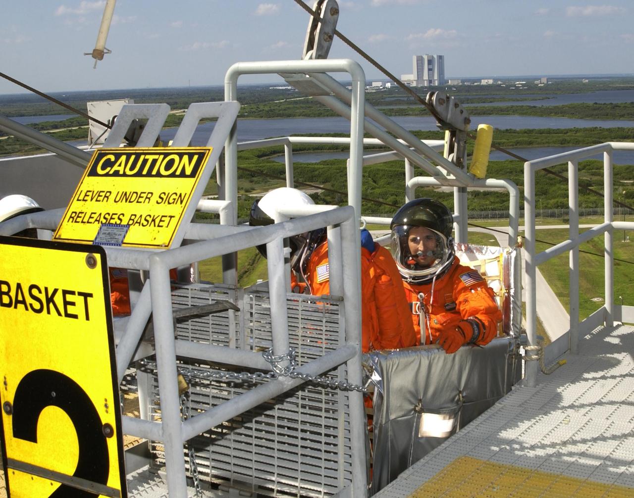 KENNEDY SPACE CENTER, FLA. -  STS-113 Mission Specialists Michael Lopez-Alegria (left) and John Herrington (right) climb into the slidewire basket during emergency egress practice from the 195-foot level of the Fixed Service Structure on Launch Pad 39A.   The 16th assembly flight to the International Space Station, STS-113 will carry the Port 1 (P1) truss aboard Space Shuttle Endeavour as well as the Expedition 6 crew, who will replace Expedition 5 on the Station. Mission STS-113 is scheduled to launch Nov. 10, 2002.  