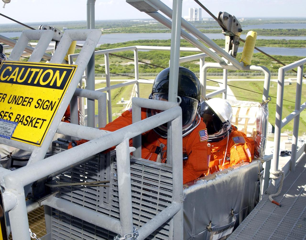 KENNEDY SPACE CENTER, FLA. - STS-113 Commander James Wetherbee (left) reaches for the release level on the slidewire basket during emergency egress practice from the 195-foot level of the Fixed Service Structure on Launch Pad 39A.  At right is Pilot Paul Lockhart.    The 16th assembly flight to the International Space Station, STS-113 will carry the Port 1 (P1) truss aboard Space Shuttle Endeavour as well as the Expedition 6 crew, who will replace Expedition 5 on the Station. Mission STS-113 is scheduled to launch Nov. 10, 2002.    