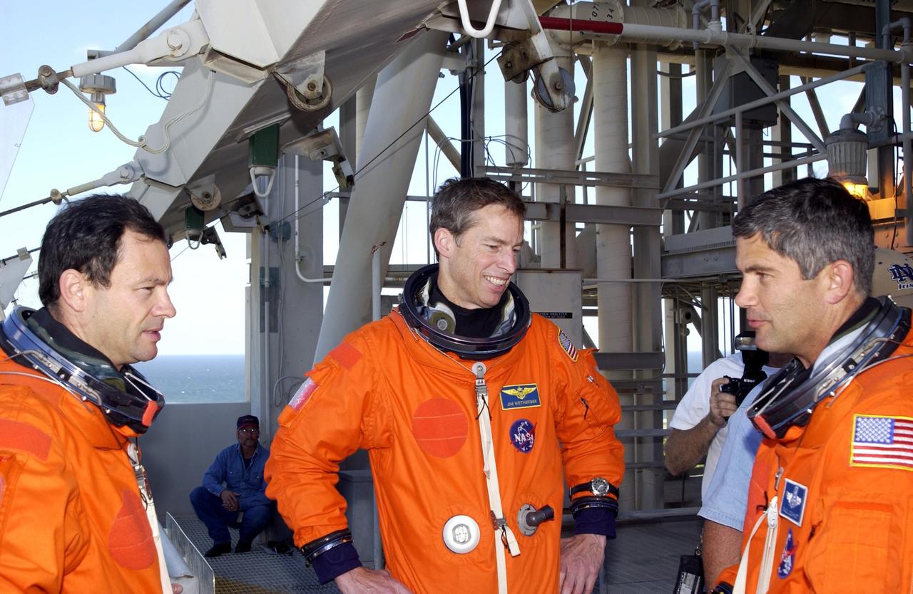 KENNEDY SPACE CENTER, FLA. -- STS-113 crew members pause during a break in emergency egress practice from the 195-foot level of the Fixed Service Structure on Launch Pad 39A.  From left are Mission Specialist Michael Lopez-Alegria, Commander James Wetherbee and Pilot Paul Lockhart. The 16th assembly flight to the International Space Station, STS-113 will carry the Port 1 (P1) truss aboard Space Shuttle Endeavour, as well as Expedition 6, who will replace Expedition 5 on the Station. The mission is scheduled to launch Nov. 10, 2002.        