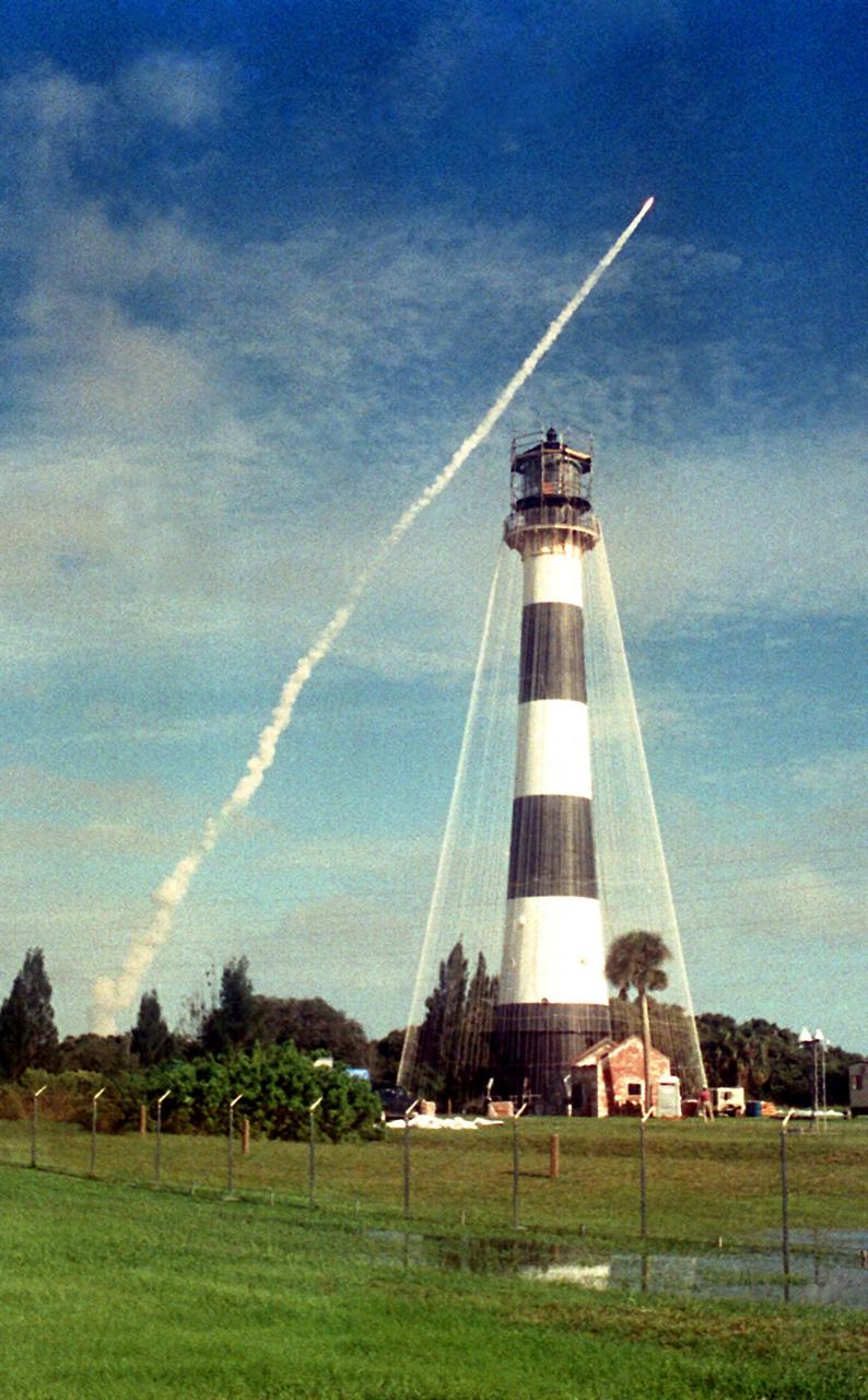 KENNEDY SPACE CENTER, FLA. -- Space Shuttle Columbia soars into the cloud-washed sky above Cape Canaveral Lighthouse.  After six scrubs from the original Sept. 25 launch date, liftoff occurred Oct. 20 at 9:53 a.m. EDT. The crew of seven comprises Commander Ken Bowersox, Pilot Kent Rominger, Mission Specialists Kathy Thornton (Payload Commander), Catherine Coleman and Michael Lopez-Alegria, plus Payload Specialists Fred Leslie and Albert Sacco.  The 72nd Shuttle mission, STS-73 marks the second flight of the U.S. Microgravity Laboratory.  Research is being conducted in five areas: fluid physics, materials science, biotechnology, combustion science, and commercial space processing.  The lighthouse, undergoing refurbishment and upgrade,  is shown with a network of nylon lines ready for canvas panels to be attached.  The canvas shroud will protect the surrounding area during sand-blasting of the lead-based paint.