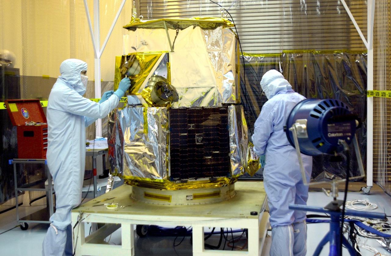 KENNEDY SPACE CENTER, FLA. - In the Multi-Purpose Processing Facility, workers adjust the SORCE satellite for a solar array test.  SORCE is equipped with four instruments that will measure variations in solar radiation much more accurately than anything now in use and observe some of the spectral properties of solar radiation for the first time. With data from NASA’s SORCE mission, researchers should be able to follow how the Sun affects our climate now and in the future.  The SORCE project is managed by NASA’s Goddard Space Flight Center.  The instruments on the SORCE spacecraft are built by the Laboratory for Atmospheric and Space Physics (LASP).  Launch of SORCE aboard a Pegasus XL rocket is scheduled for mid-December 2002.  Launch site is Cape Canaveral Air Force Station, Fla.
