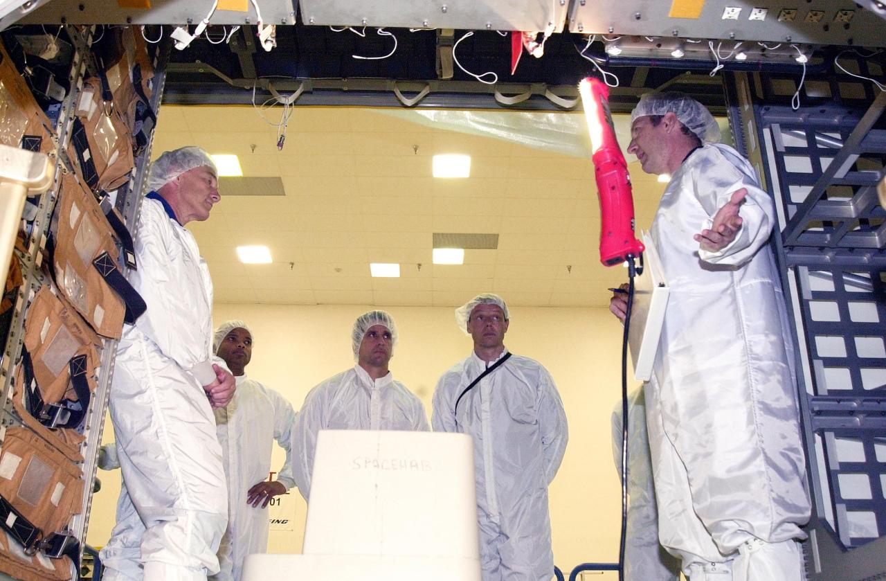 KENNEDY SPACE CENTER, FLA. -- STS-116 crew members take part in equipment familiarization in the SPACEHAB module. From left are Mission Commander Terrence Wilcutt, Mission Specialist Robert Curbeam, Pilot William Oefelein and Mission Specialist Christer Fugelsang, who is with the European Space Agency. At right is a SPACEHAB trainer. Objective of their mission to the International Space Station is to deliver and attach the third port truss segment, the P5 Truss, deactivate and retract P6 Truss Channel 4B (port-side) solar array, reconfigure station power from 2A and 4A solar arrays, deliver the Expedition 8 crew to the Station and return the Expedition 7 crew to Earth. The mission is currently targeted for launch in July 2003.