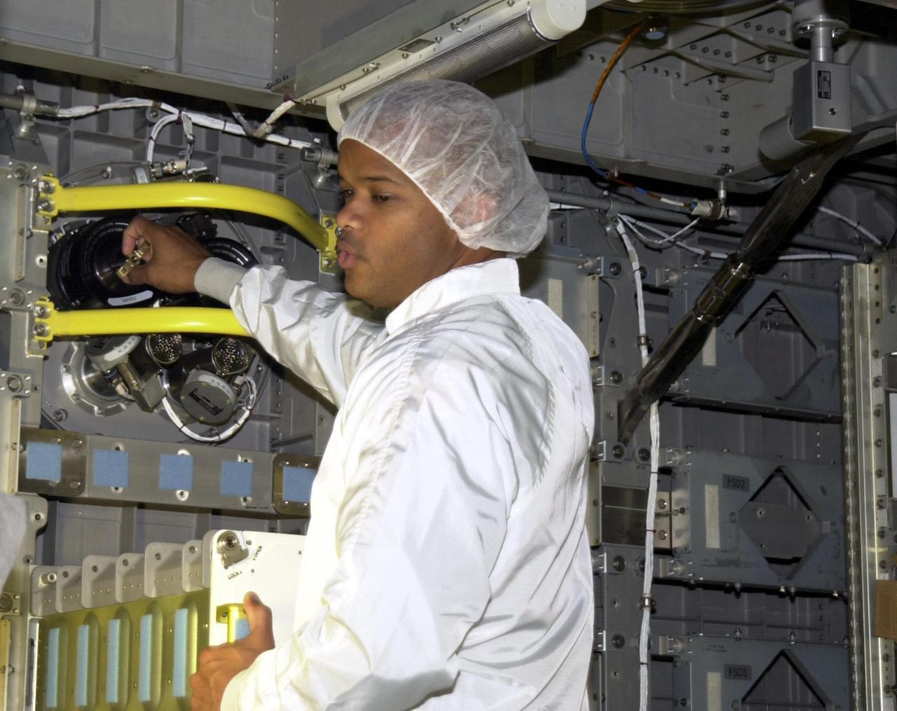 KENNEDY SPACE CENTER, FLA. -- STS-116 Mission Specialist Robert Curbeam handles a piece of equipment in the SPACEHAB module. He and other crew members are taking part in equipment familiarization. Objective of their mission to the International Space Station is to deliver and attach the third port truss segment, the P5 Truss, deactivate and retract P6 Truss Channel 4B (port-side) solar array, reconfigure station power from 2A and 4A solar arrays, deliver the Expedition 8 crew to the Station and return the Expedition 7 crew to Earth. The mission is currently targeted for launch in July 2003.